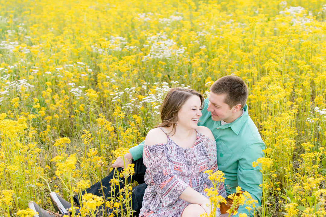 Indianapolis couple laughs in field of yellow flowers