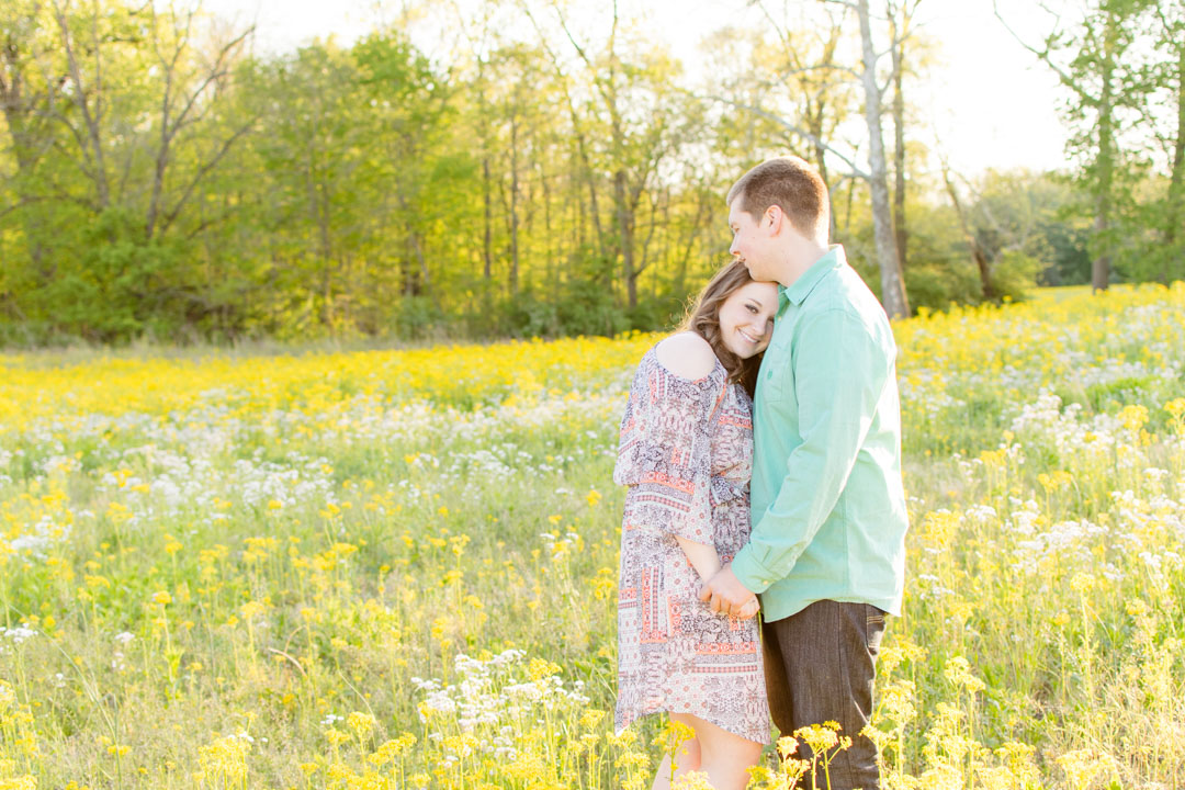Couple poses in field of yellow flowers
