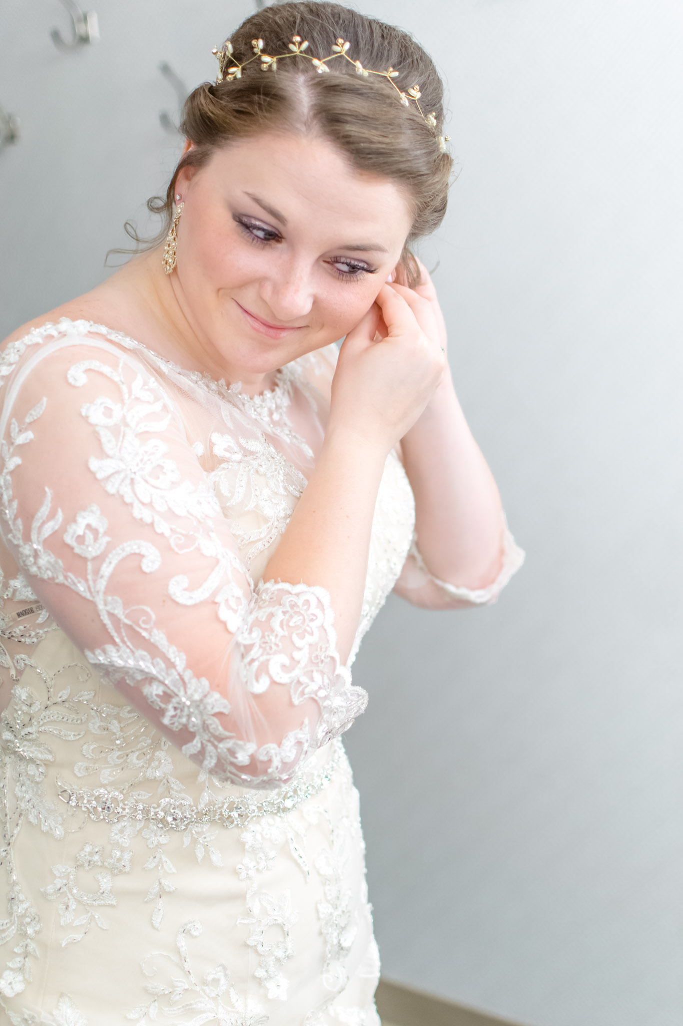 Indianapolis bride puts on earrings on wedding day