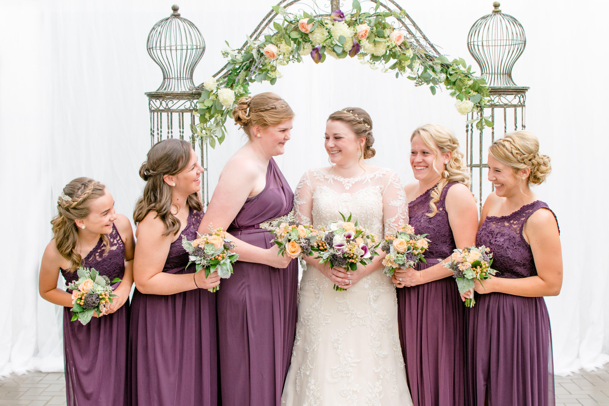 The bride and her bridal party laugh during portraits