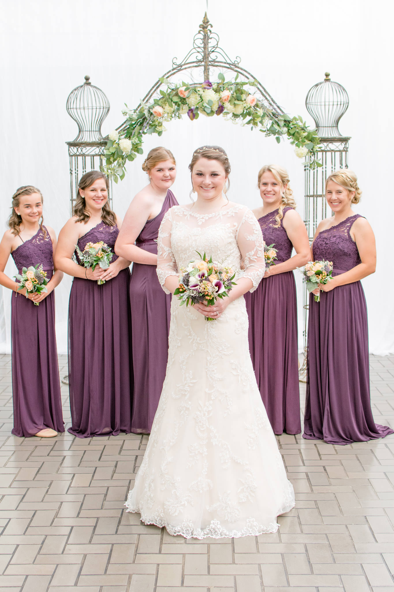 bride smiles while standing in front of bridal party