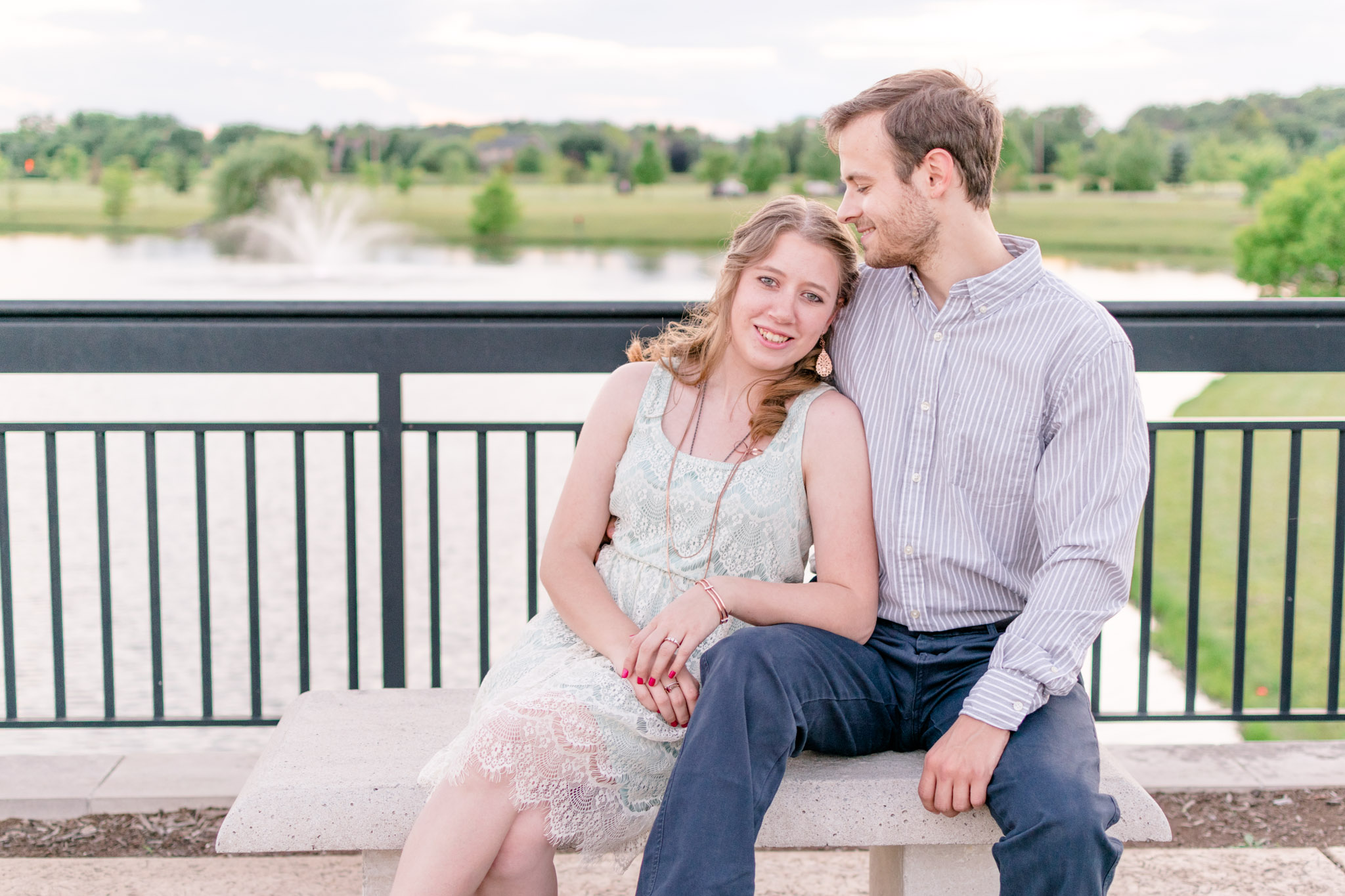 Couple cuddles on bridge at Coxhall Gardens in Carmel, Indiana