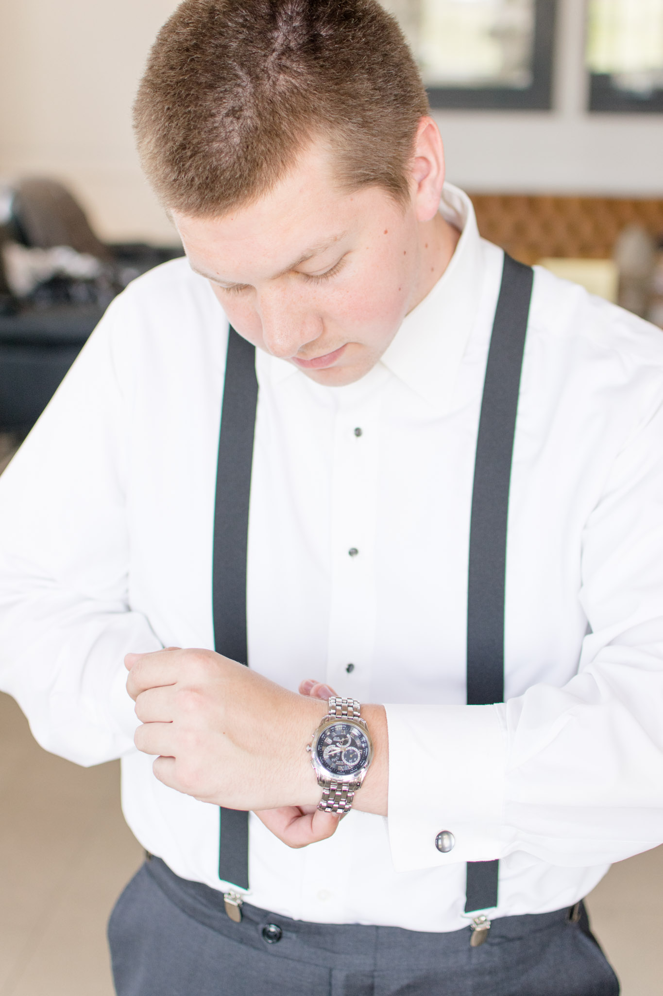 Groom fastens watch while getting ready
