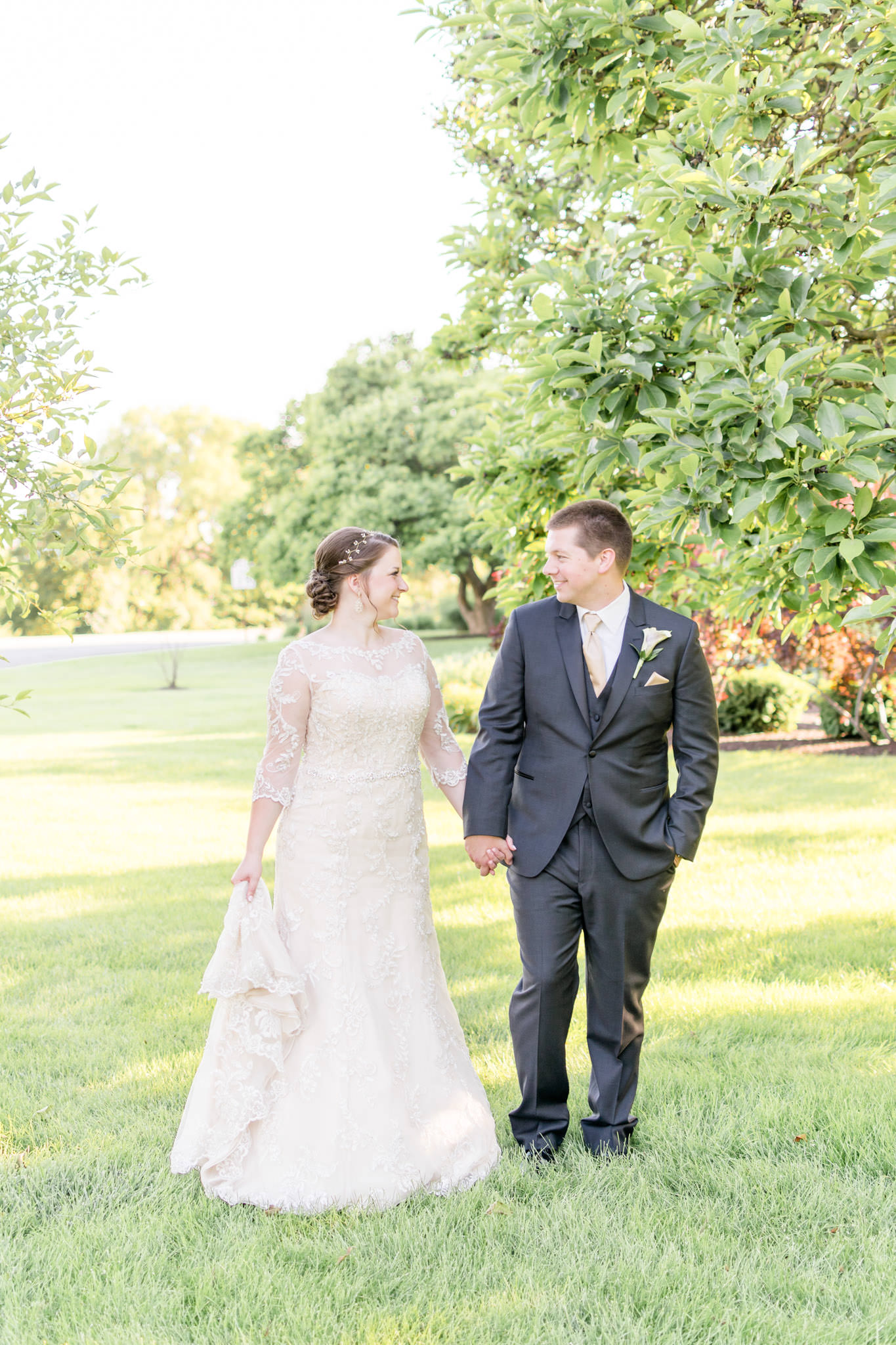 Bride and Groom walk across grass after wedding ceremony