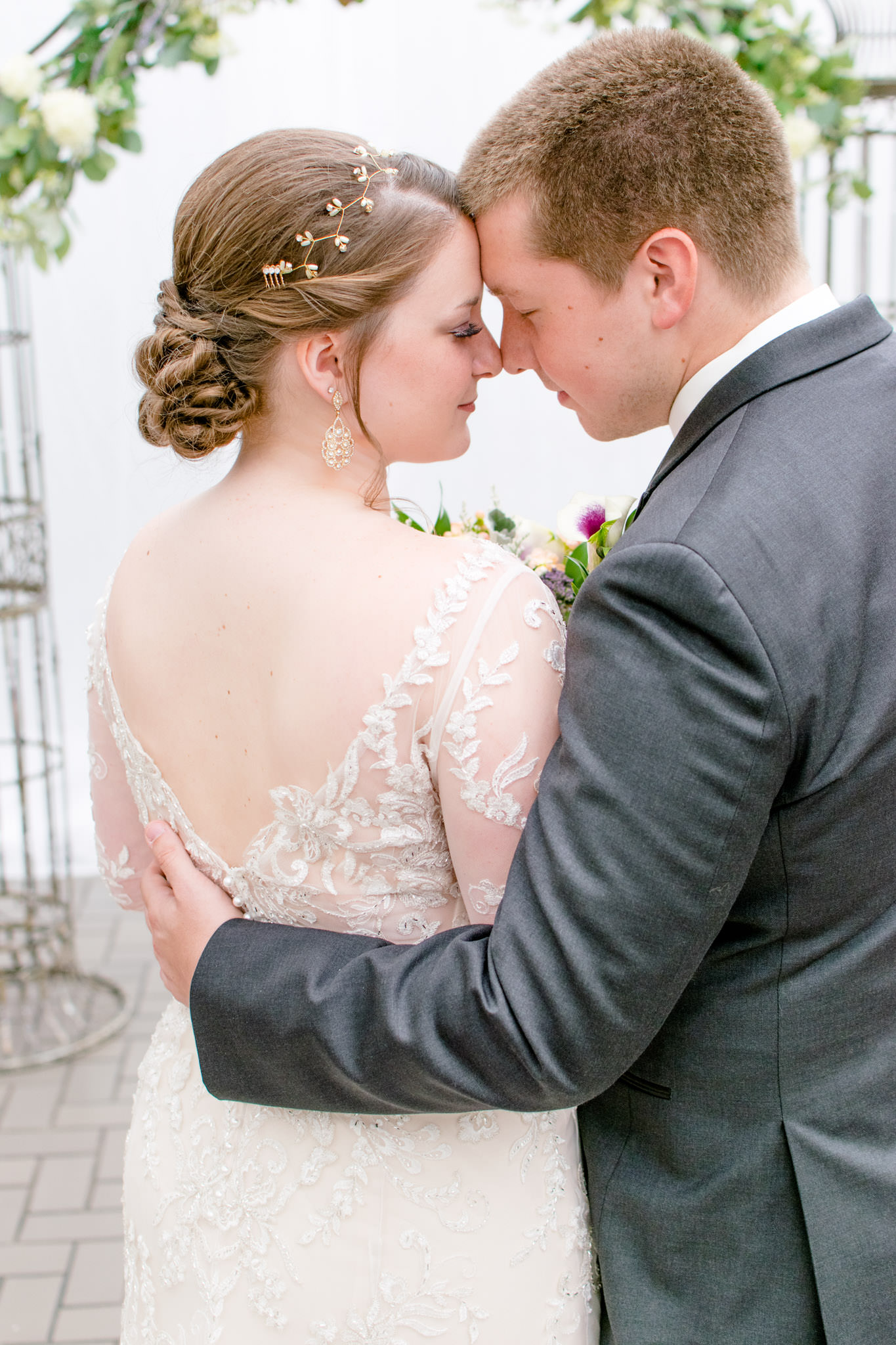Bride and groom touch foreheads during wedding portraits
