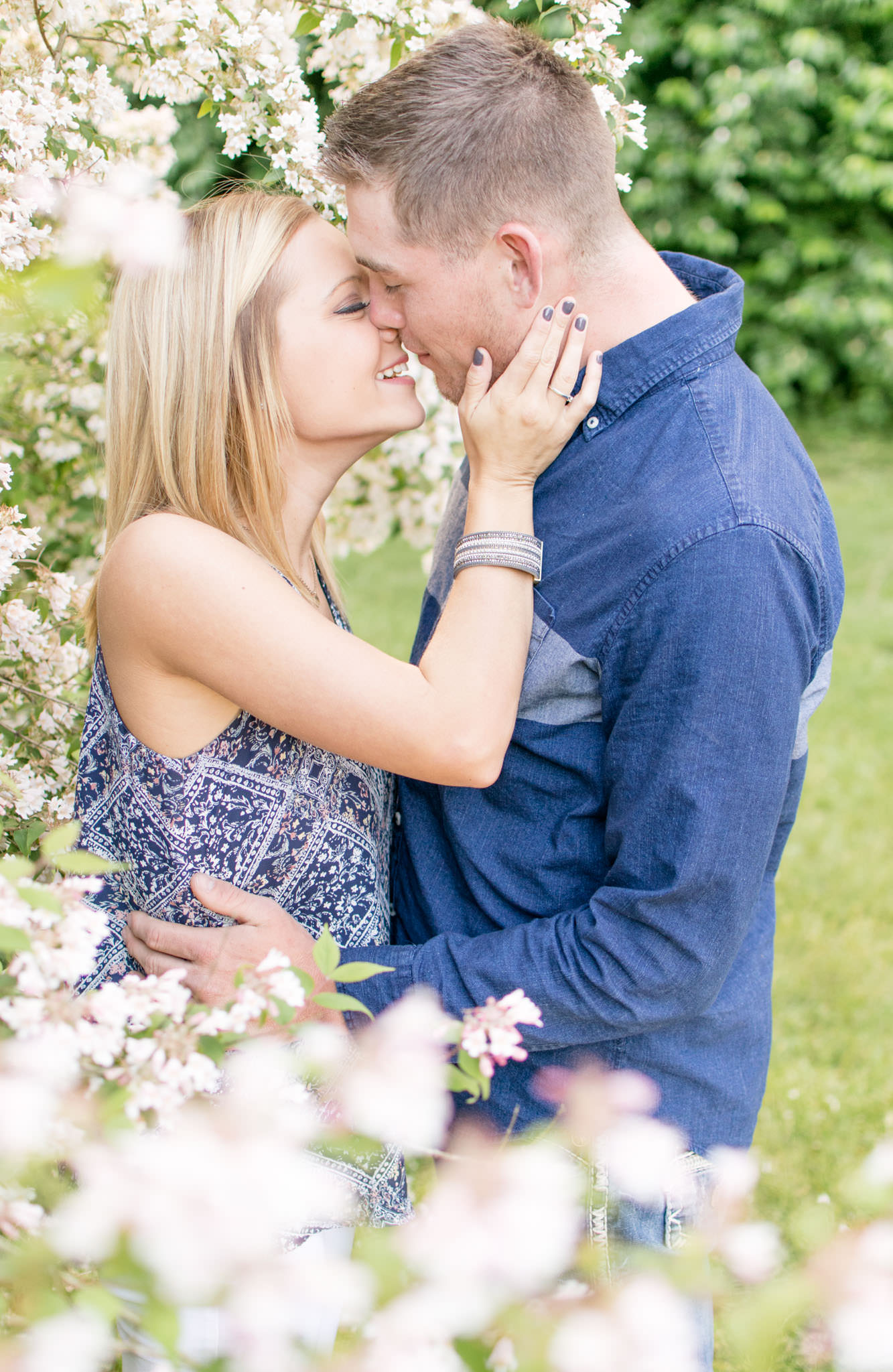 Bride and Groom kiss in flowers during Holcomb Gardens engagement pictures.