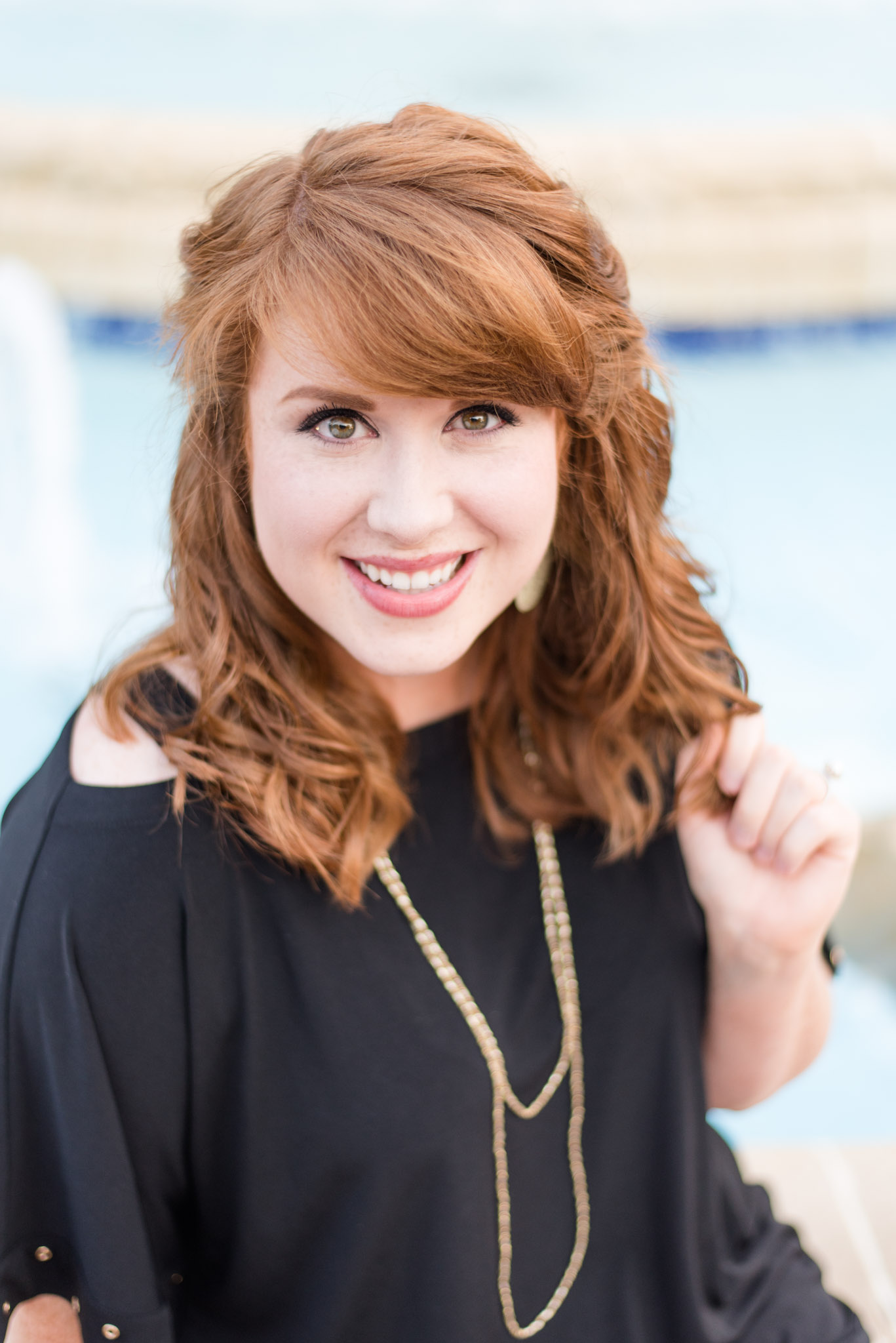 Girl smiles at camera during Senior pictures at UNA fountain