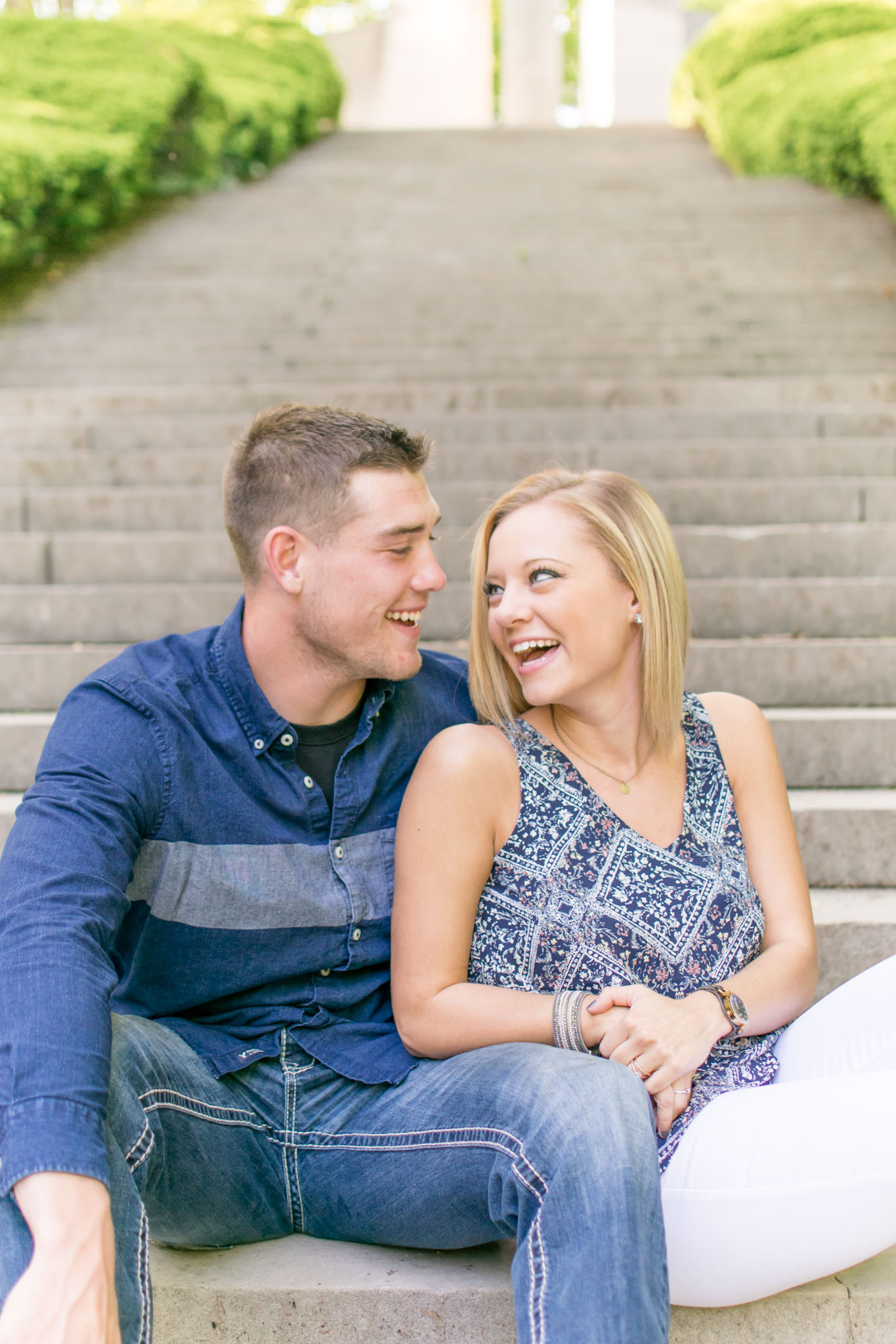 Couple laughs on stairs of Holcomb Gardens.