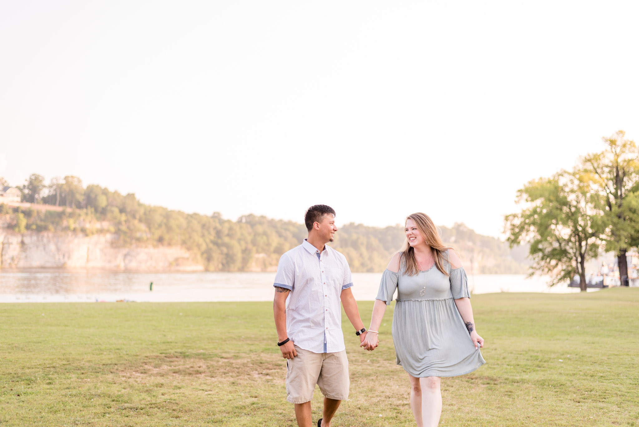 Engaged couple laughs as they walk through McFarland Park