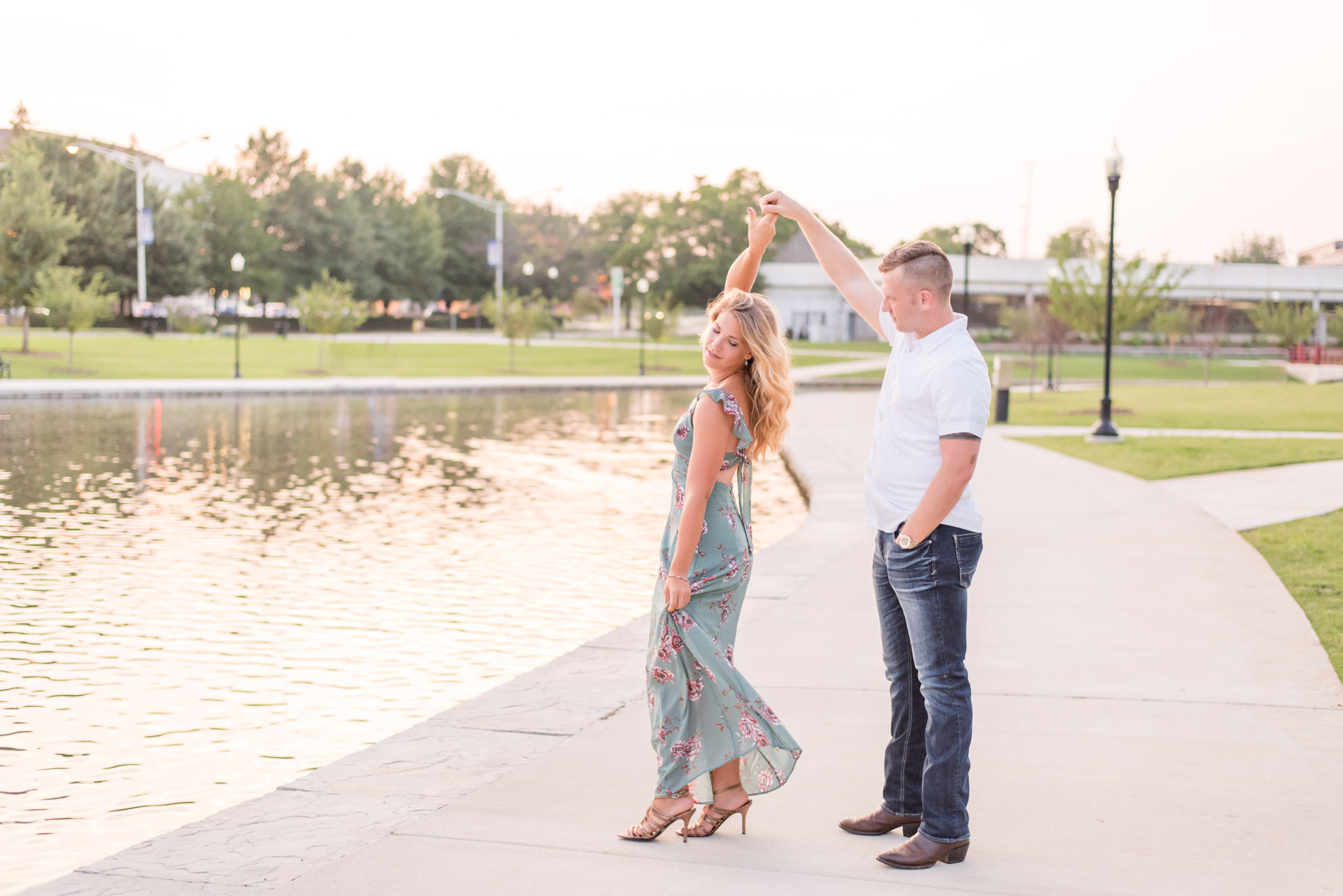 Engaged groom twirls bride during pictures.