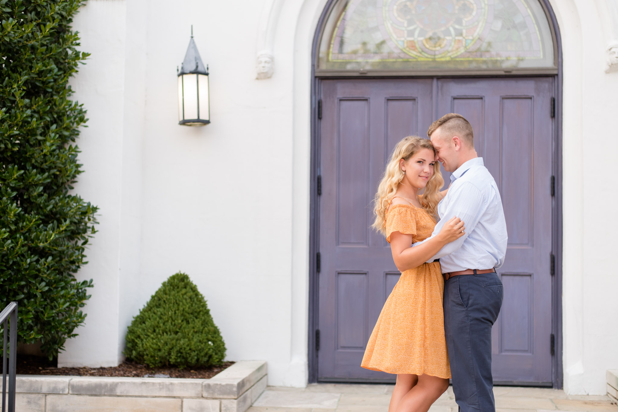 Bride smiles during pictures in front of purple door. 