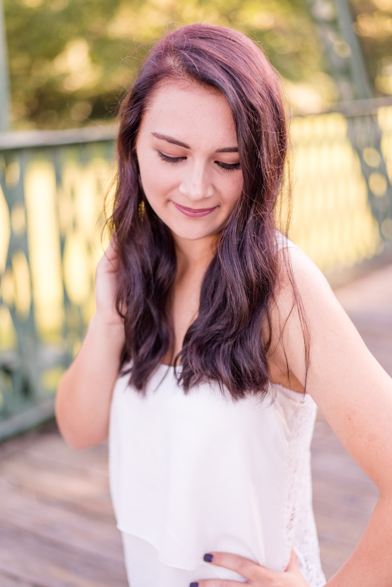 High school looks senior while looking down on bridge.