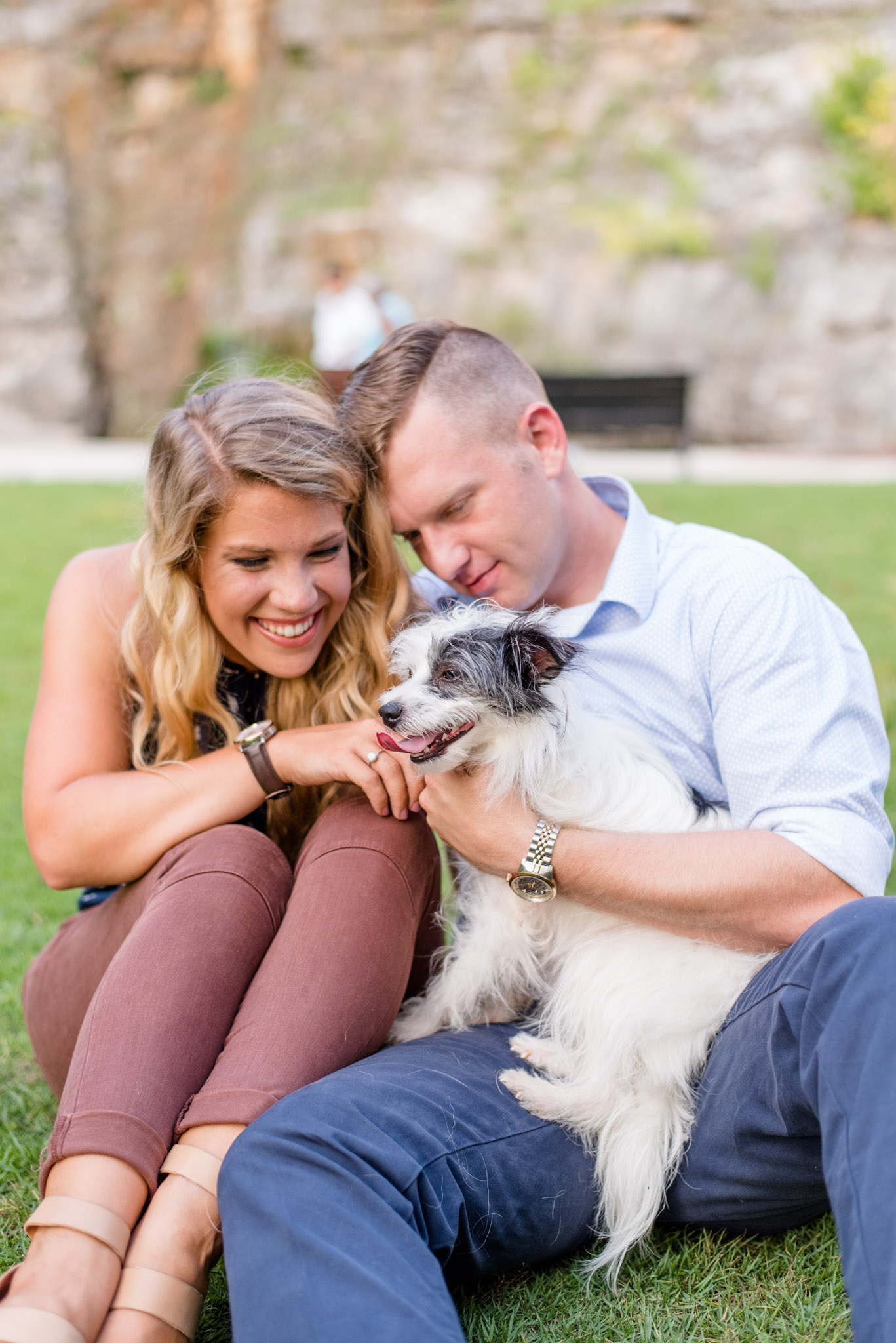 Couple plays with dog in park. 