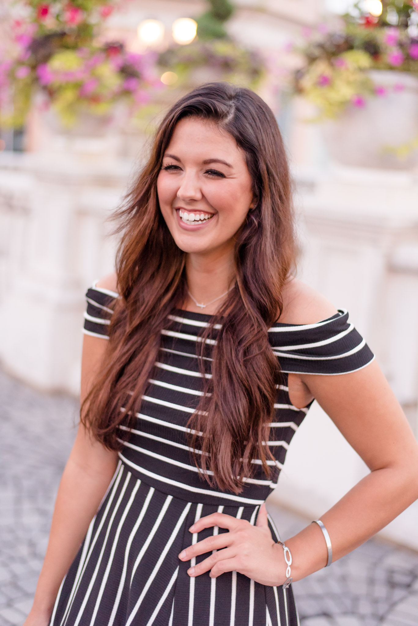 Girl smiles over shoulder on bridge.