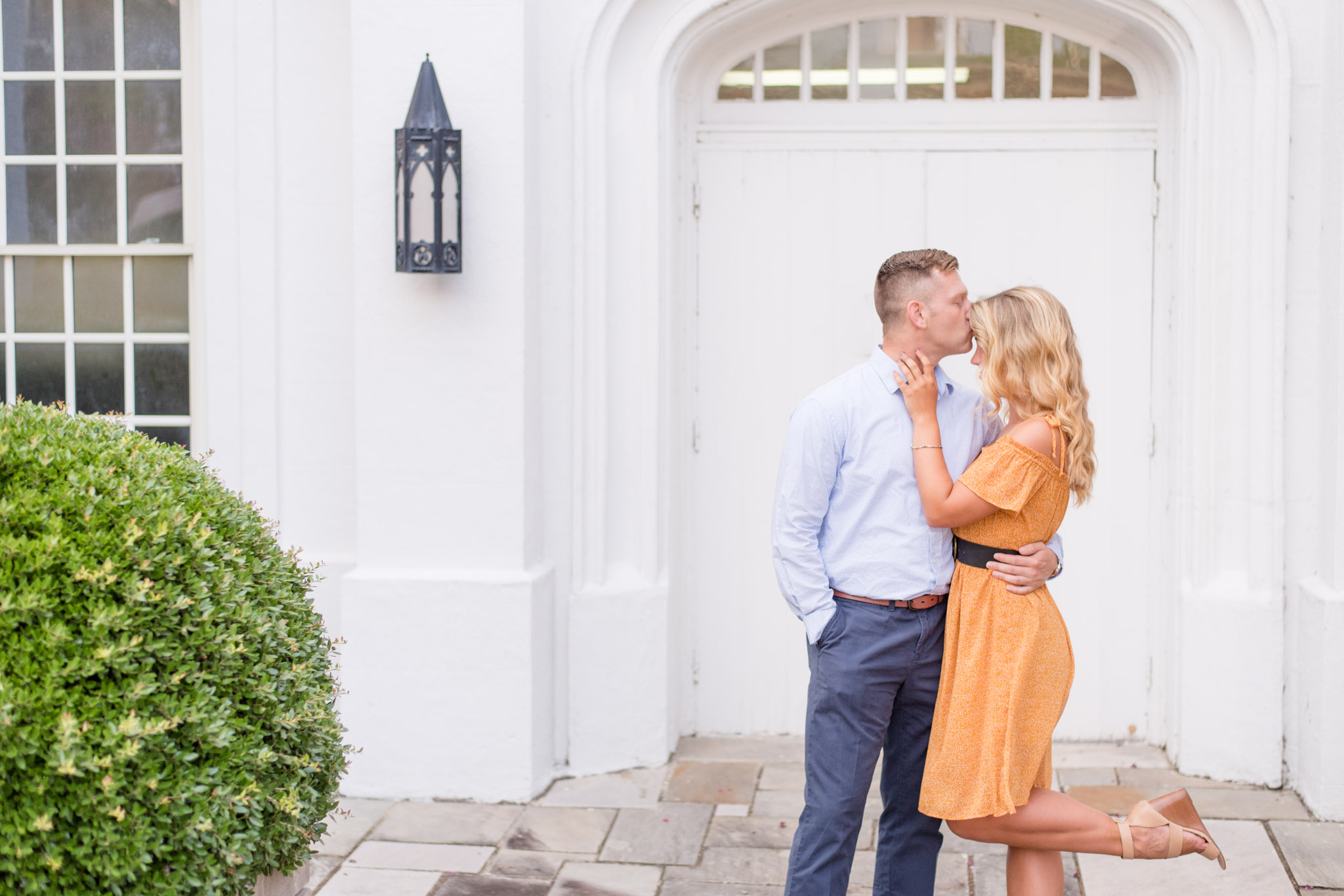 Man kisses woman on forehead.