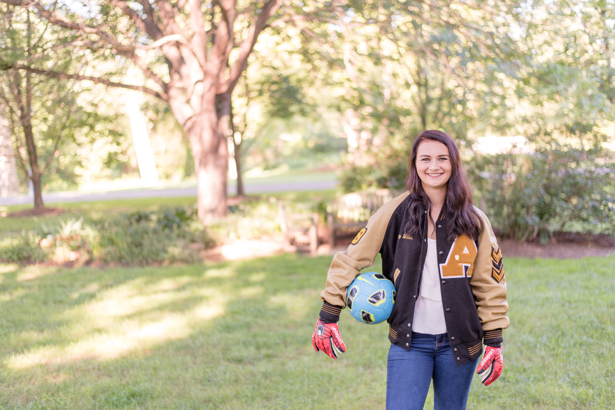 High school senior poses with soccer ball.