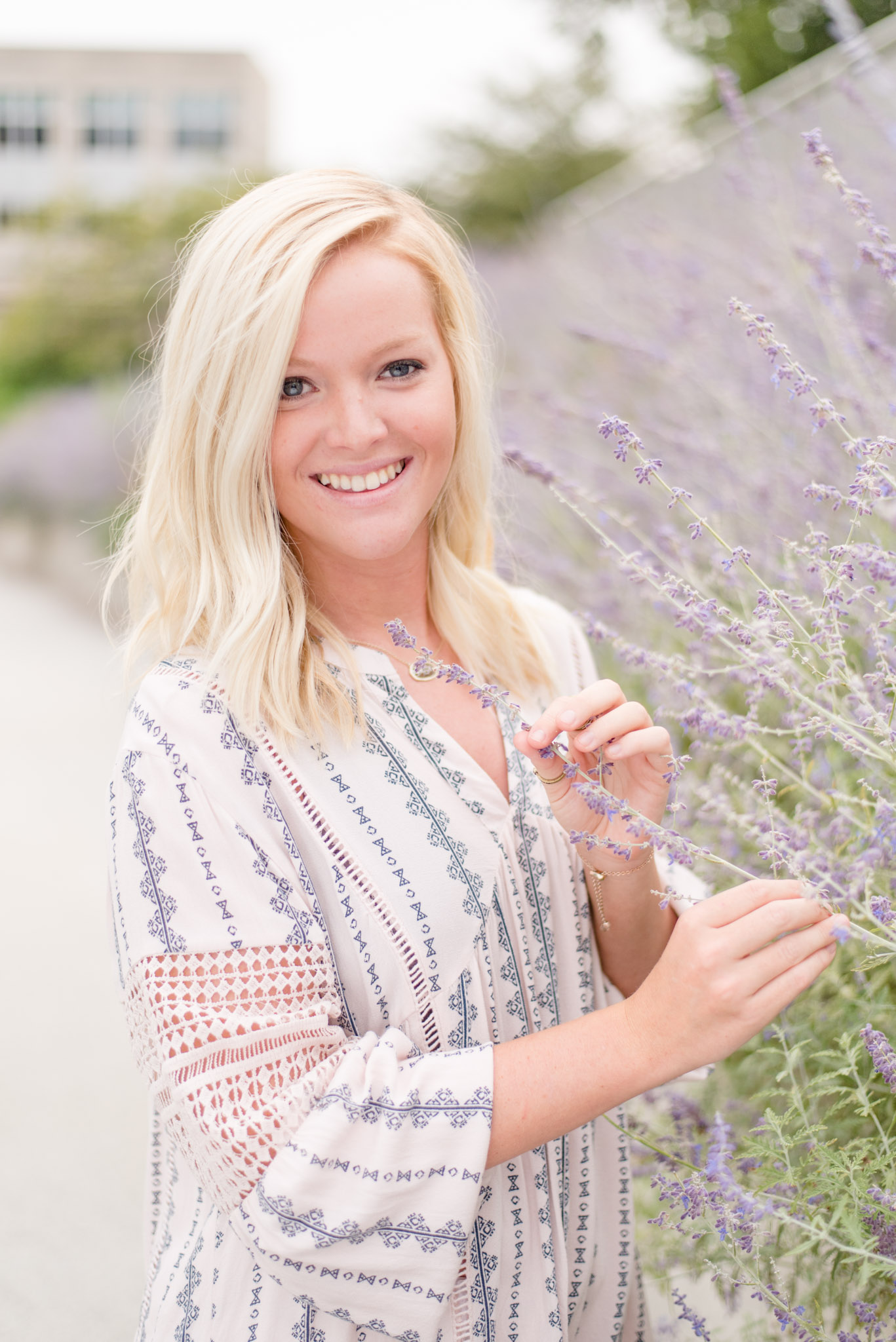 Senior smiles next to lavender on Canal Walk.