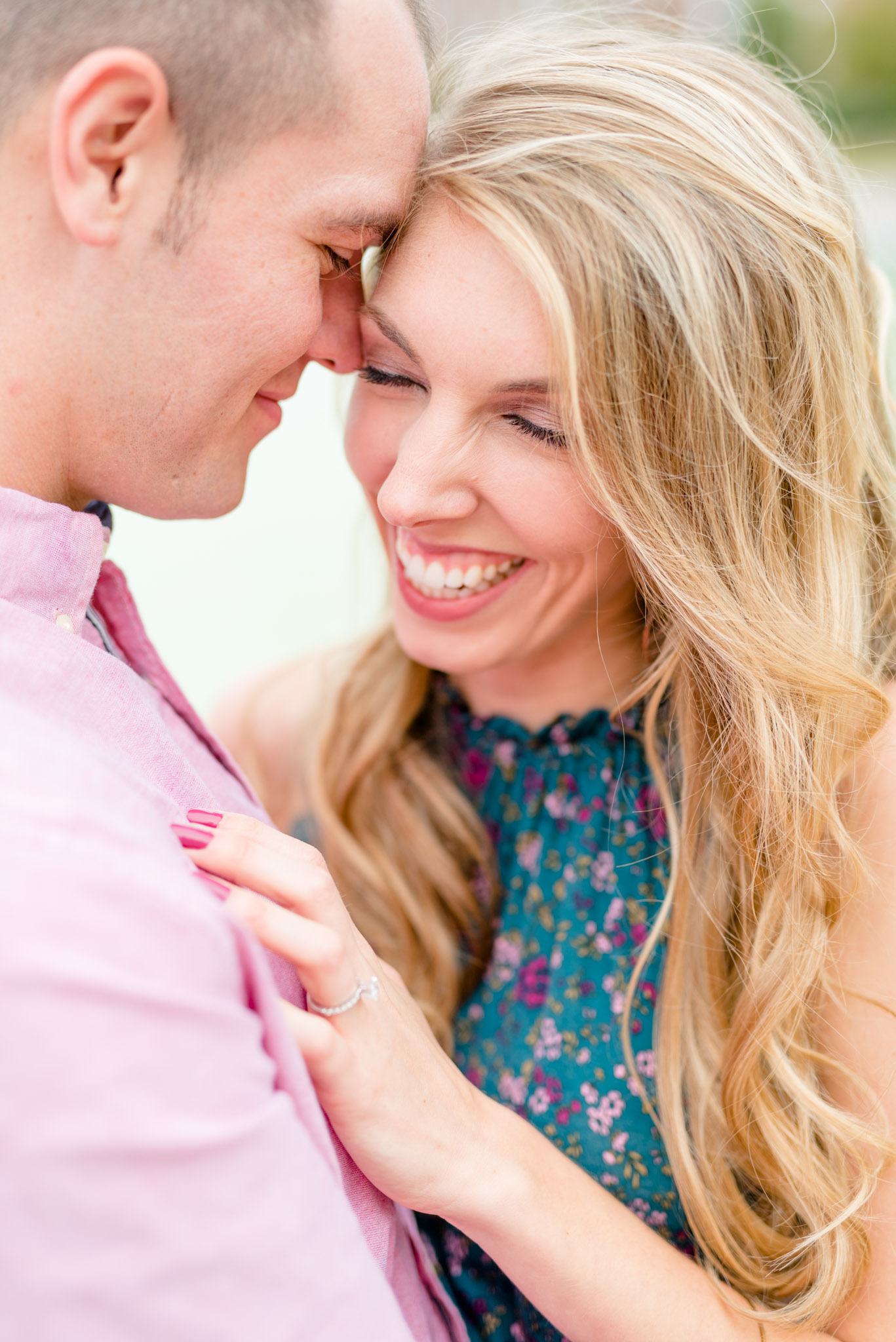 Bride and groom smile and touch foreheads during engagement pictures.