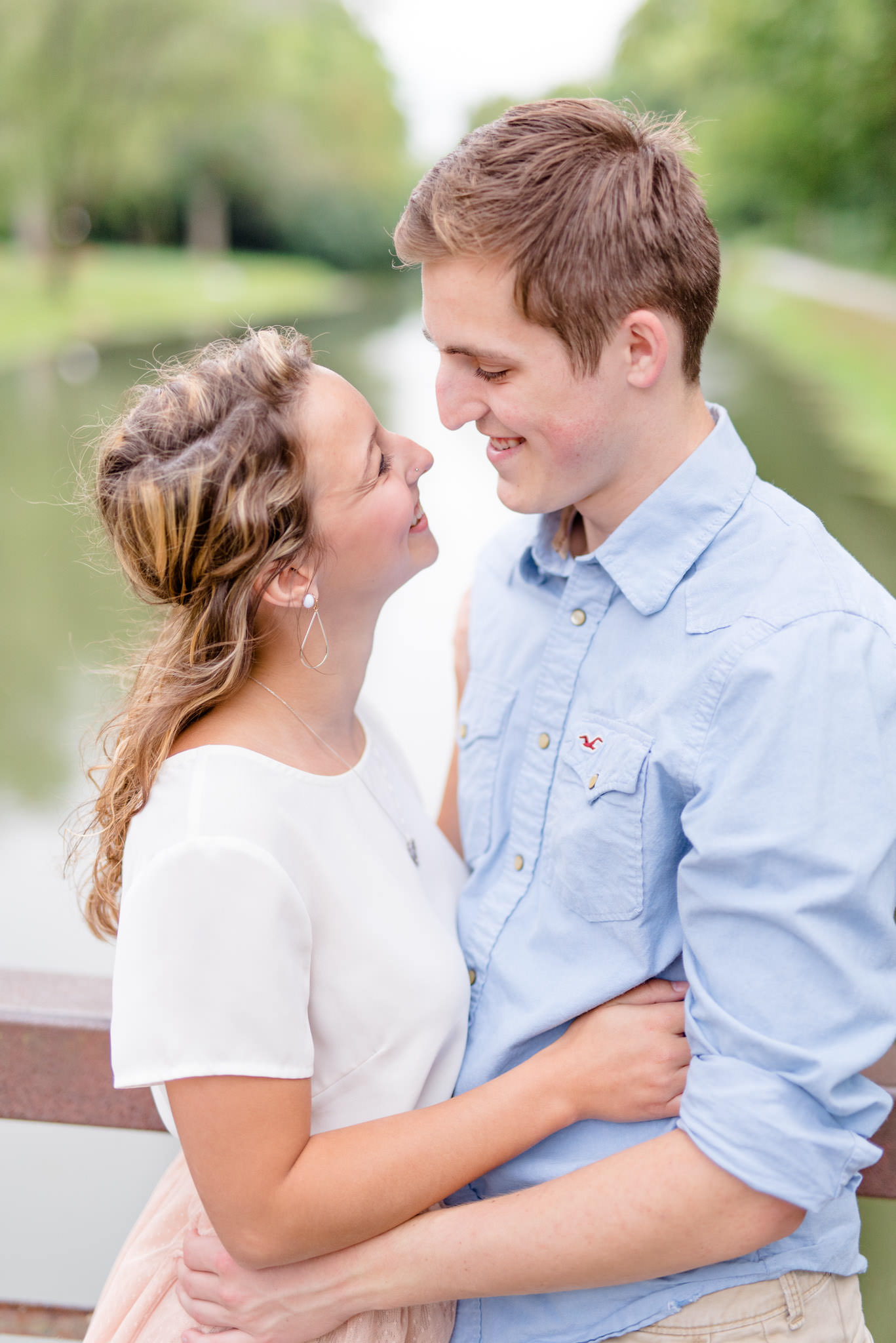 Couple looks at each other on Coxhall Gardens bridge.