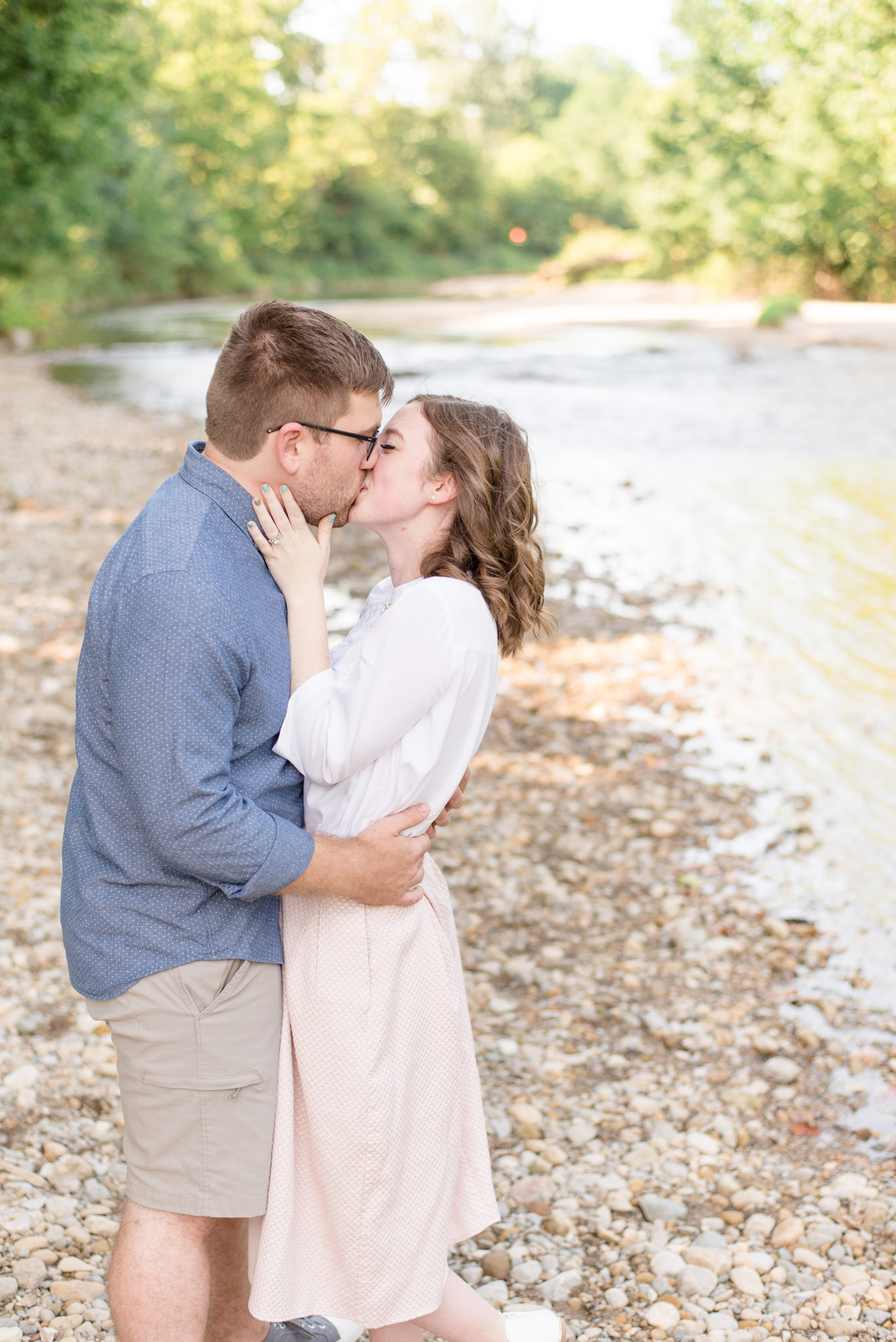 Husband and wife kiss next to Plainfield river.