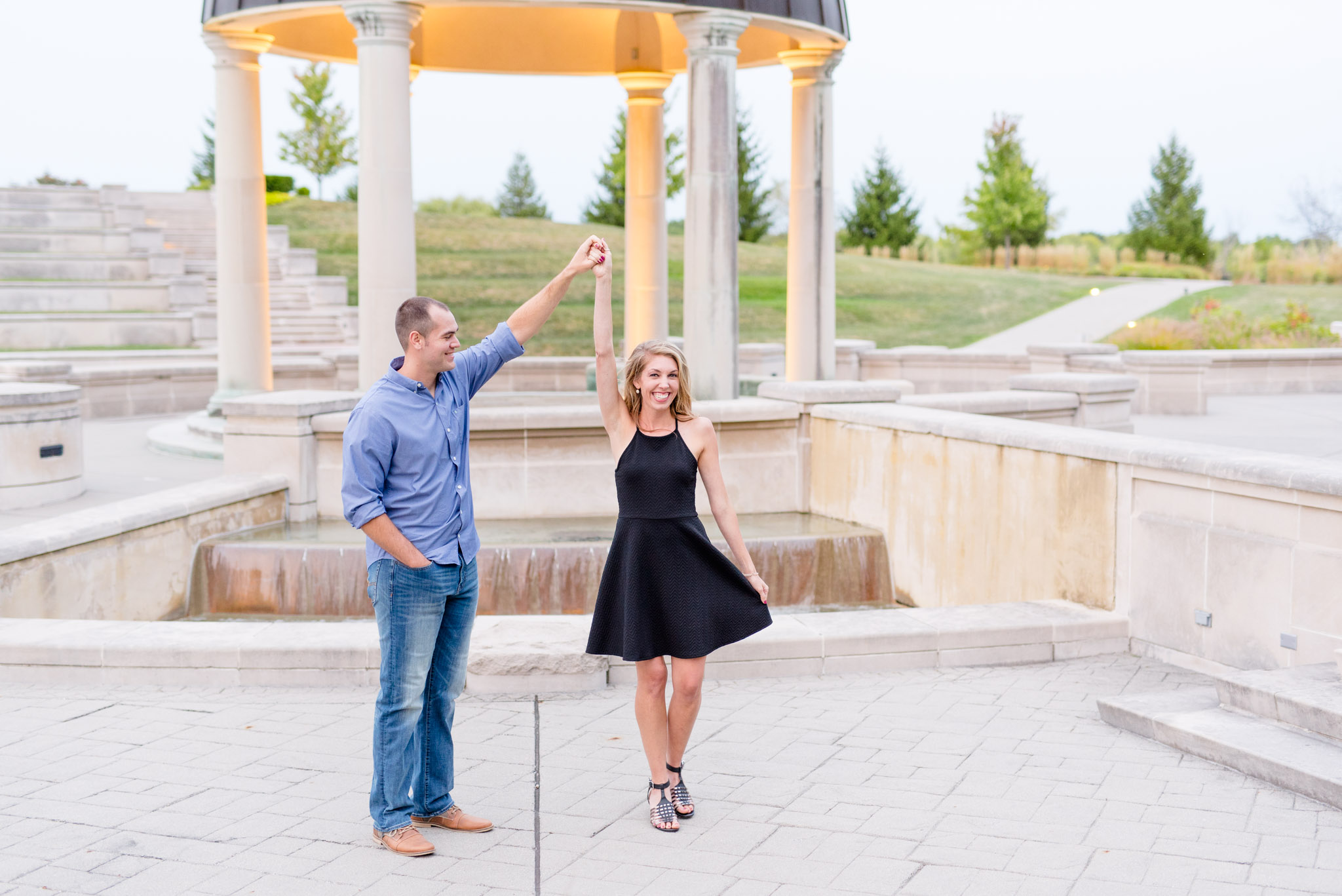 Indianapolis Groom twirls bride for engagement pictures at ampitheatre.