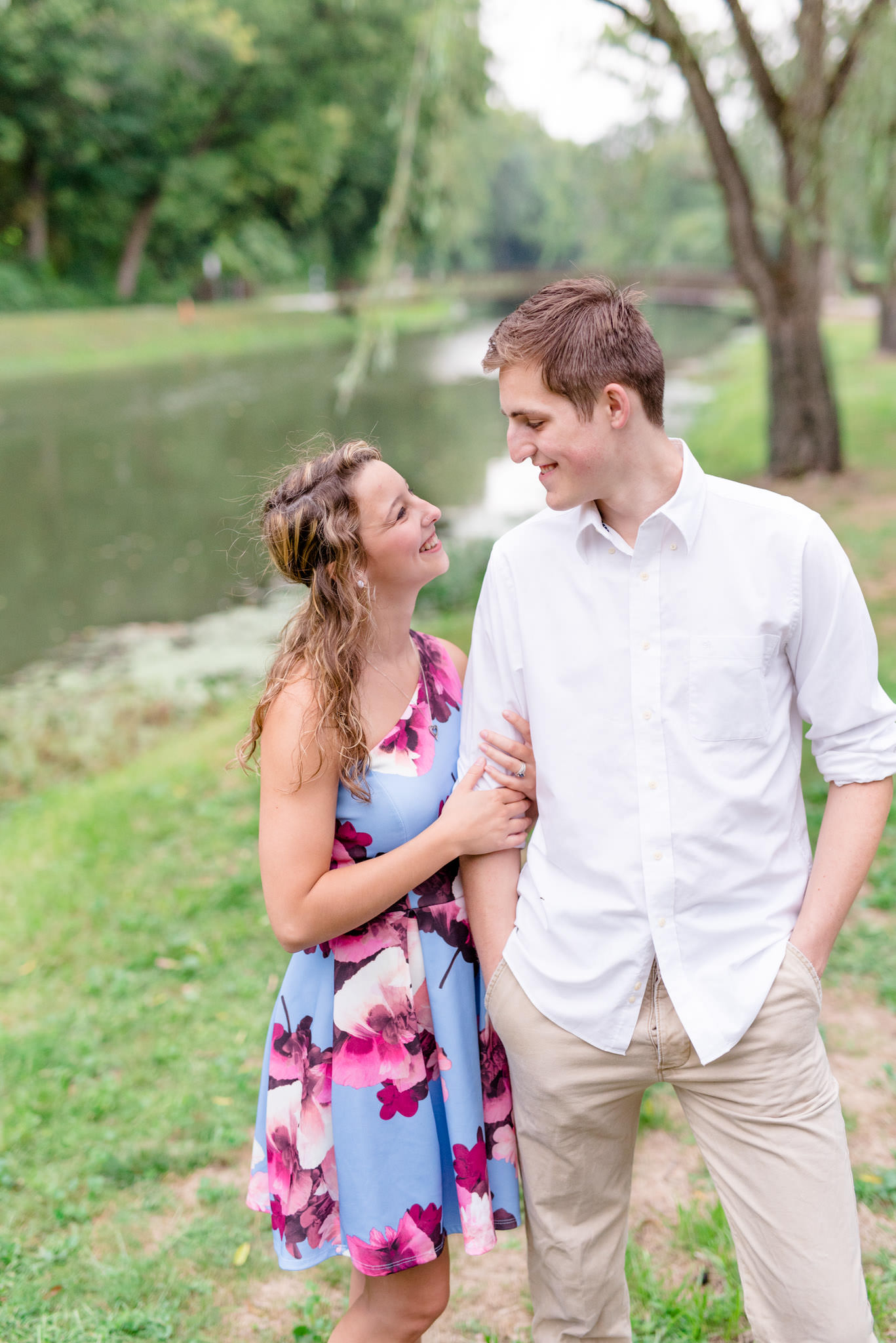Indianapolis couple smiles at each other next to river.