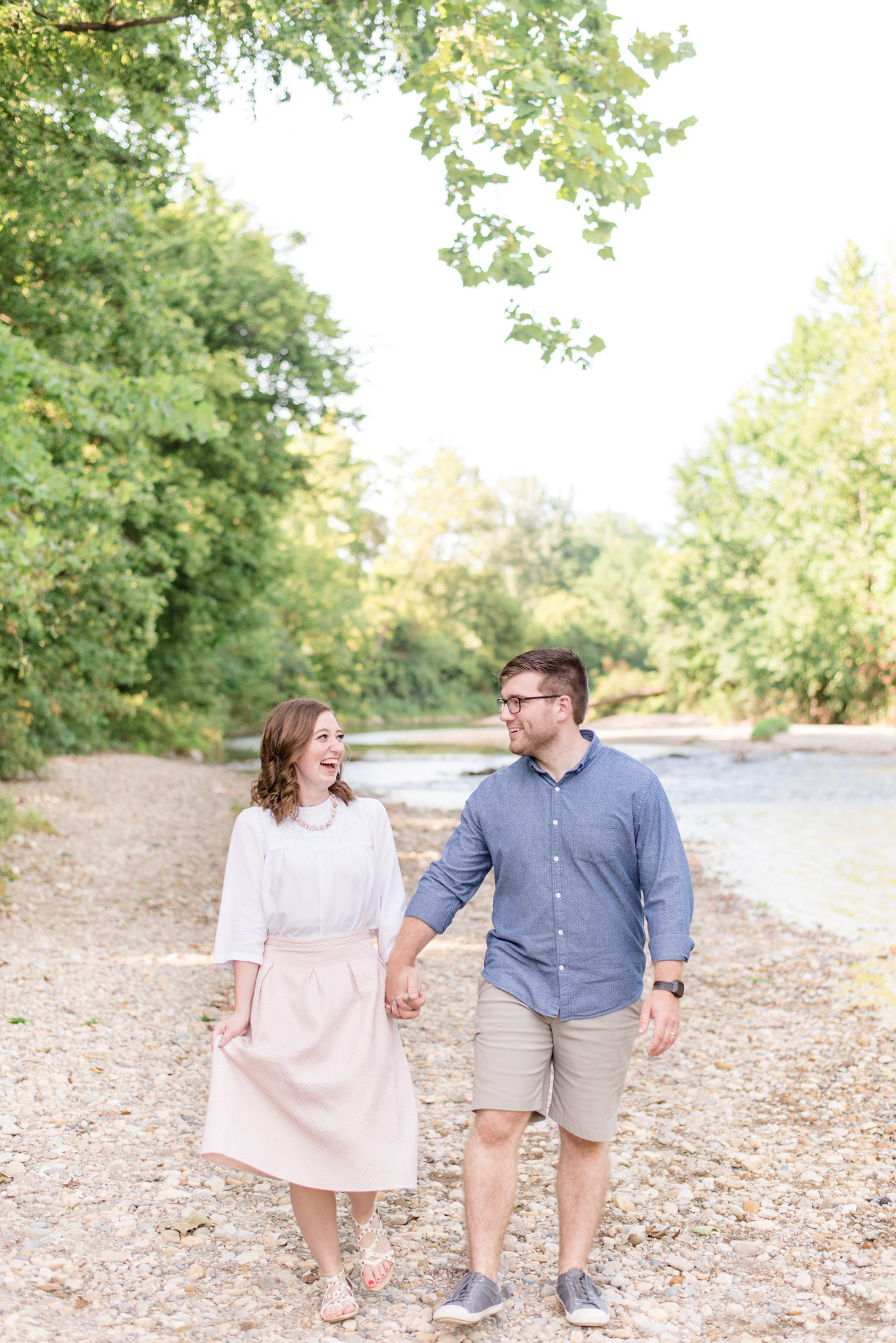 Husband and wife laugh while walking by rivers.