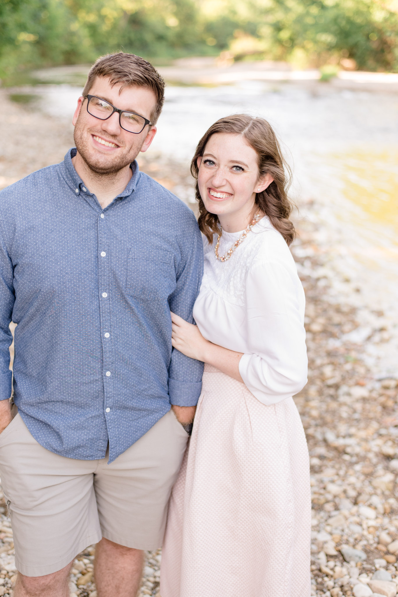 Indianapolis couple smiles at camera next to river.