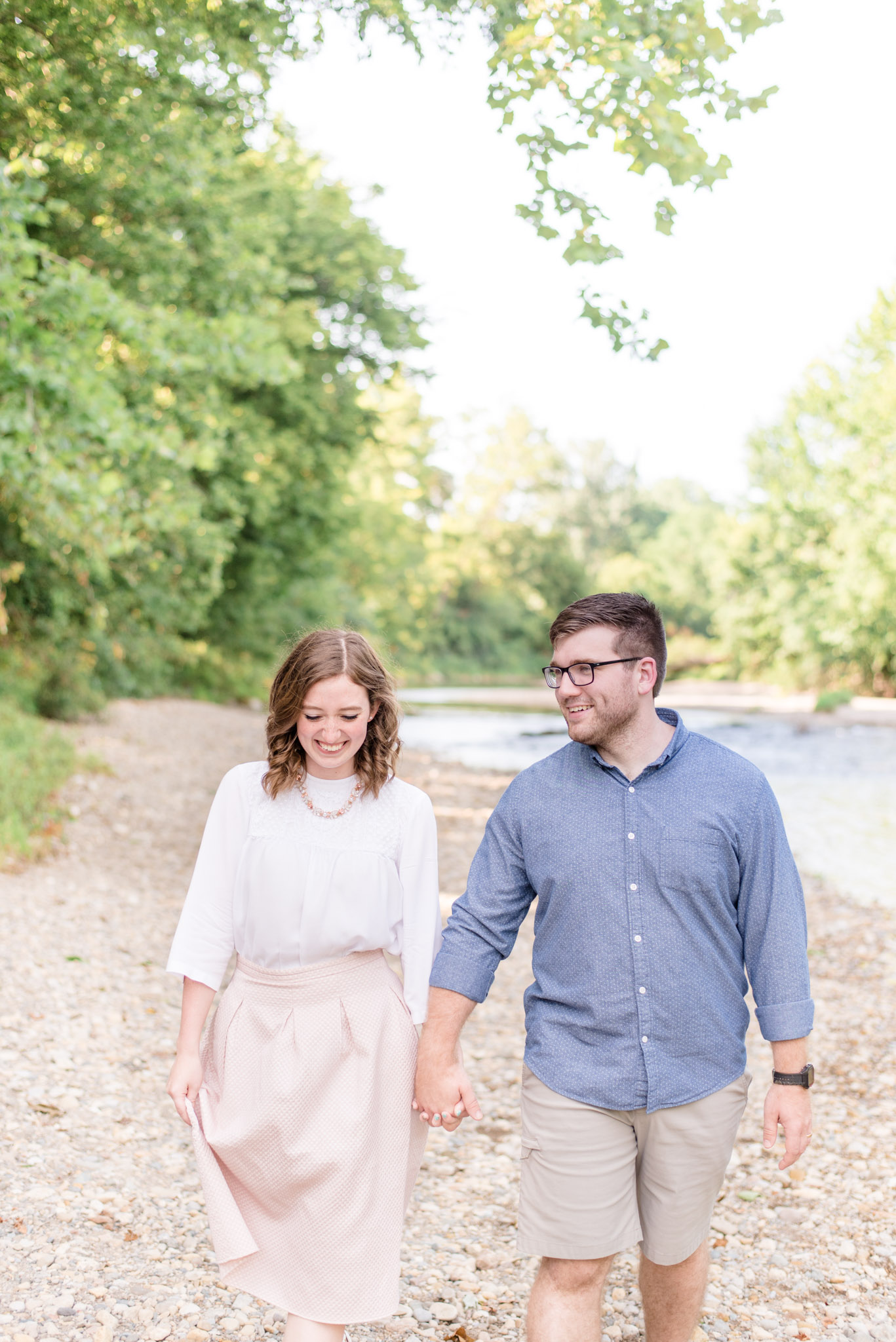 Indianapolis couple laughs as they walk next to river.