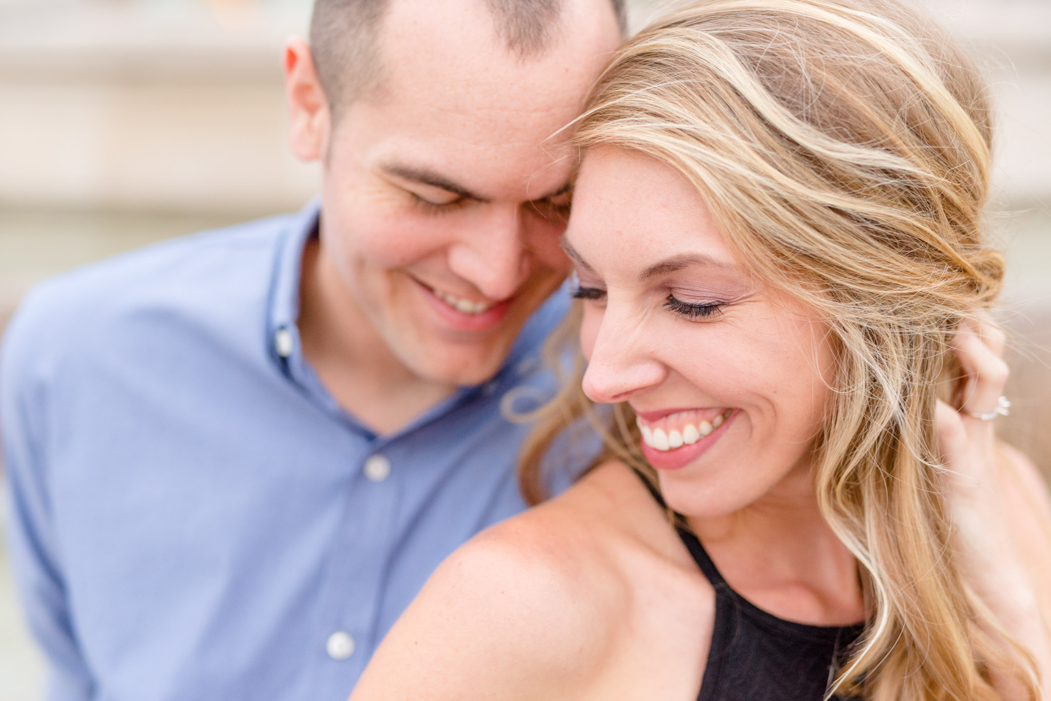 Man and woman smile and lean heads together.