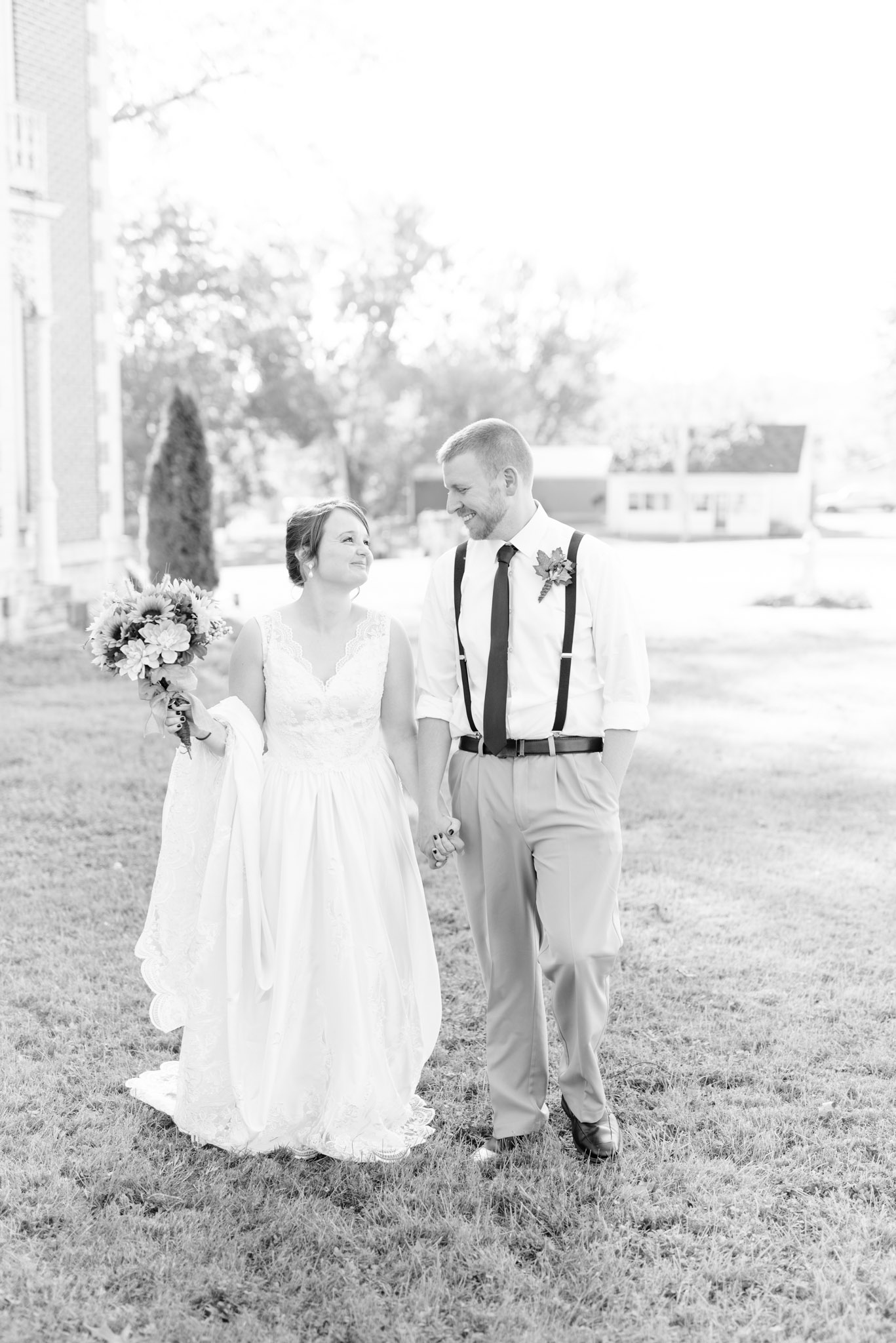 Bride and Groom walk across lawn at Wedding