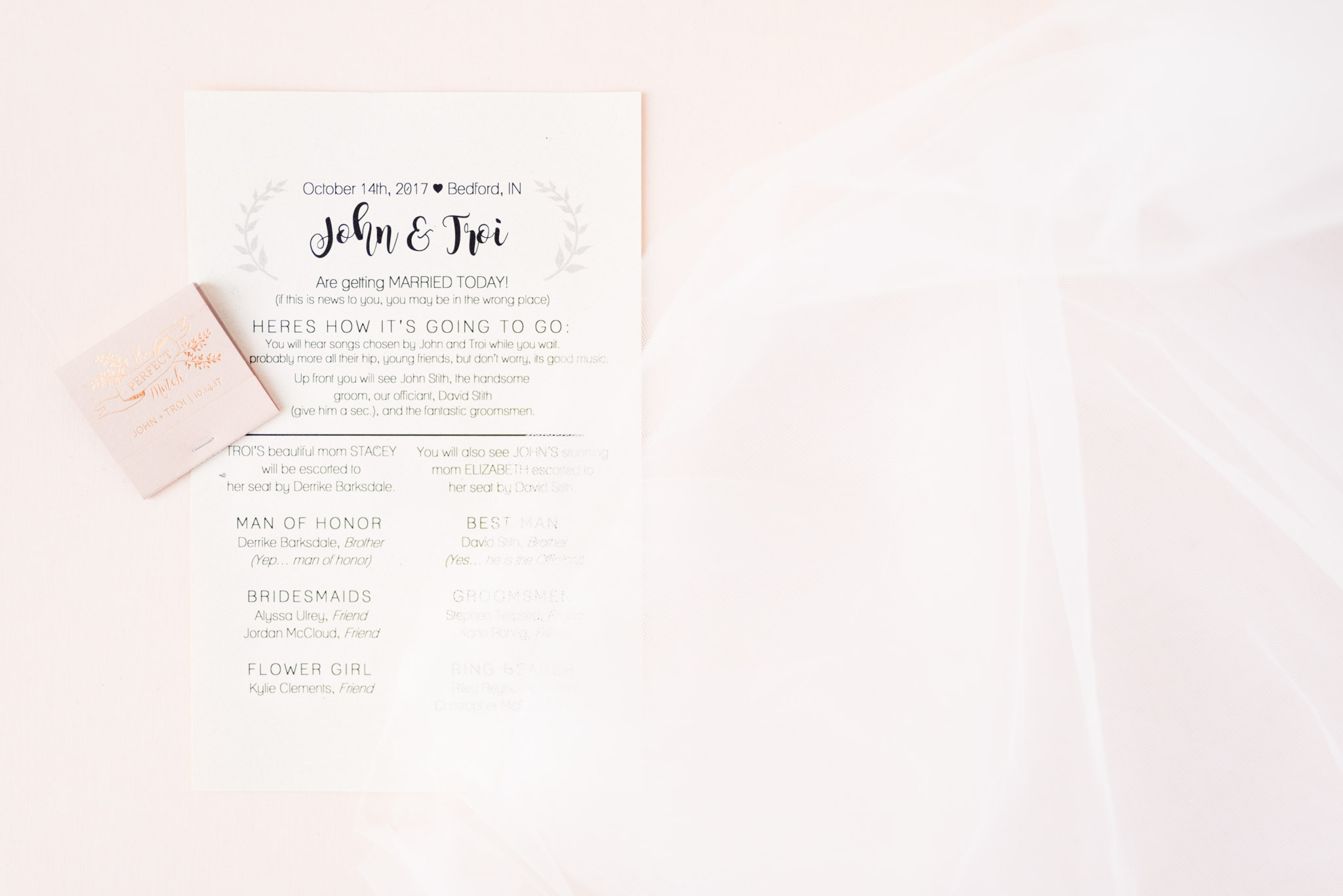 Wedding Program, Favor, and Veil lying on pink cloth.