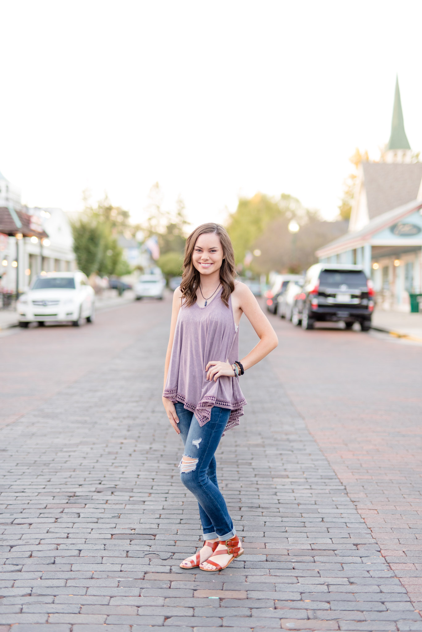 Senior girl stands on brick road in Zionsville.