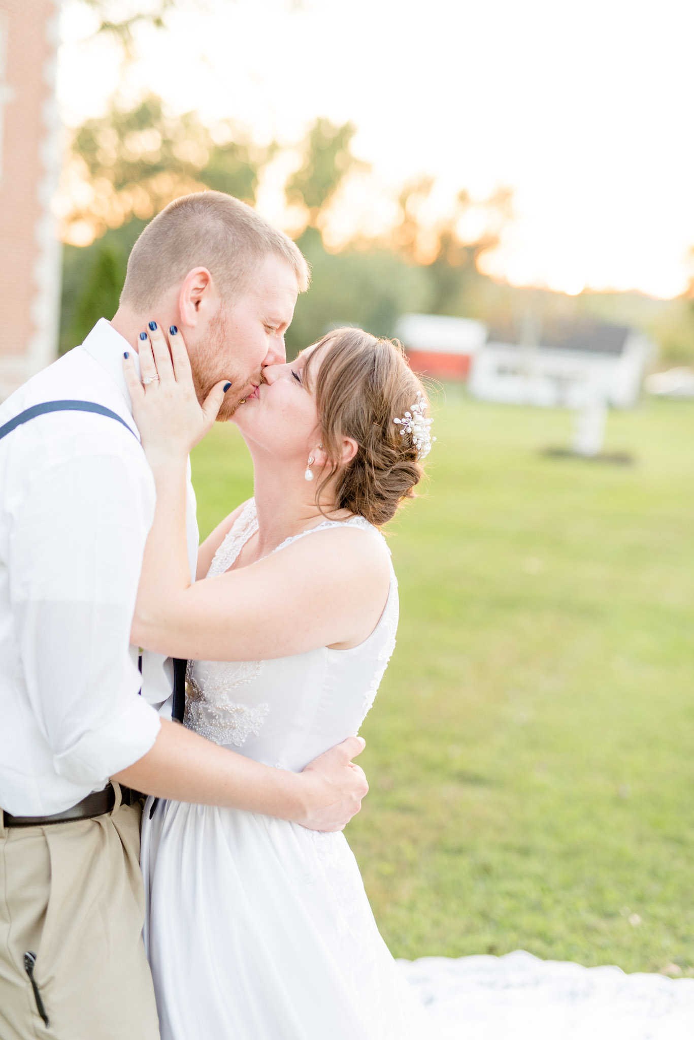 Bride and Groom Kiss at sunset on lawn.