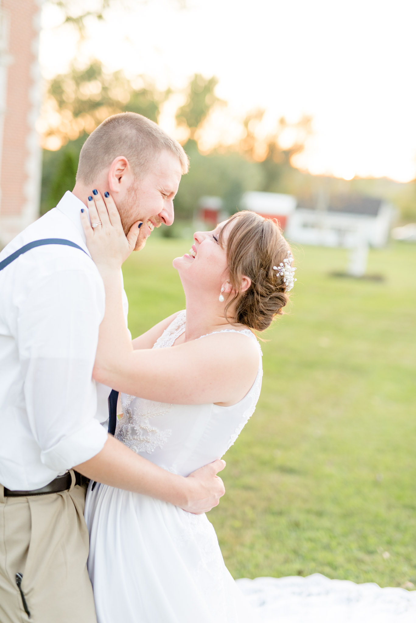 Bride and groom laugh at sunset.