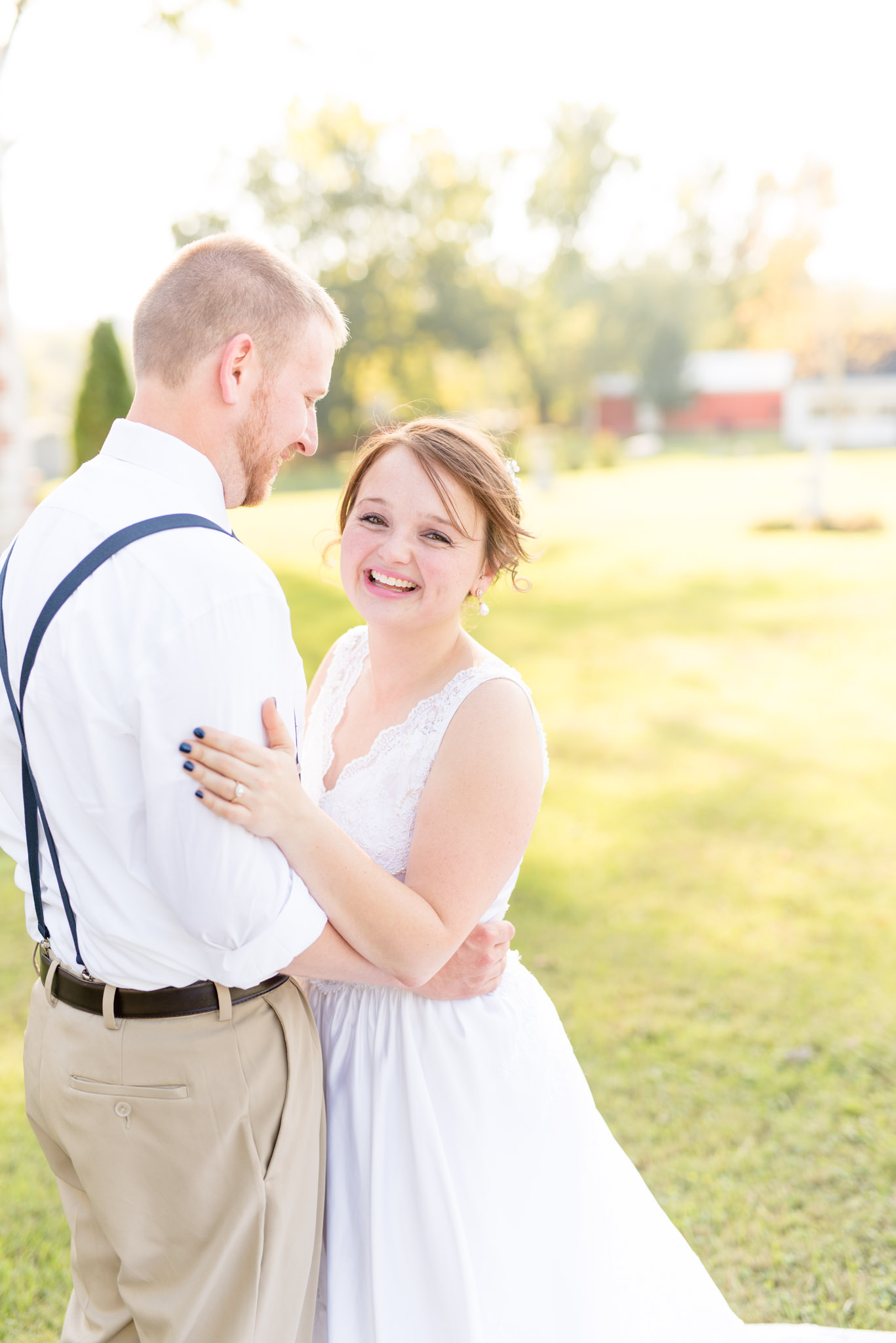 Bride looks at camera and groom looks at her.