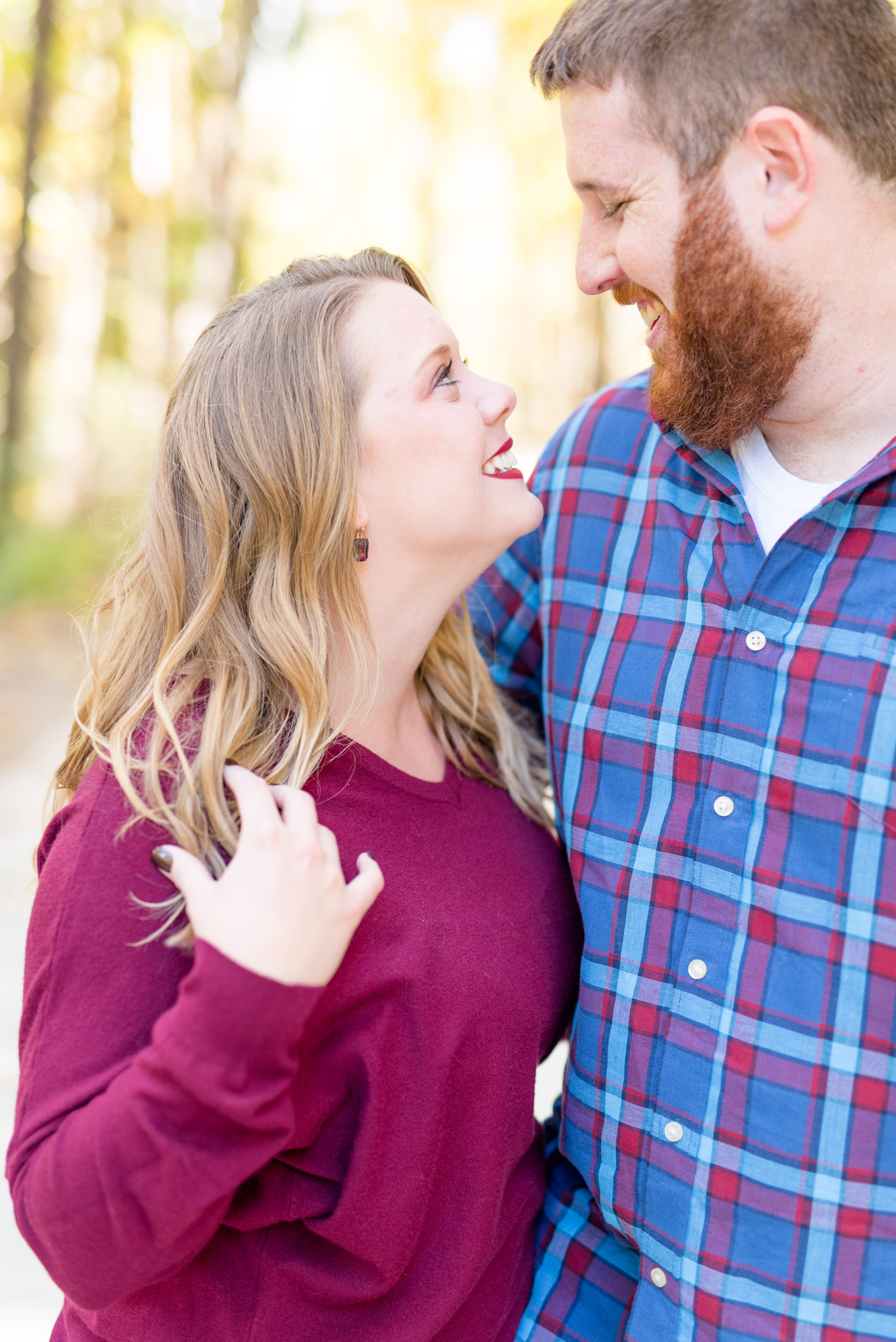 Couple smiles at each other during engagement session.