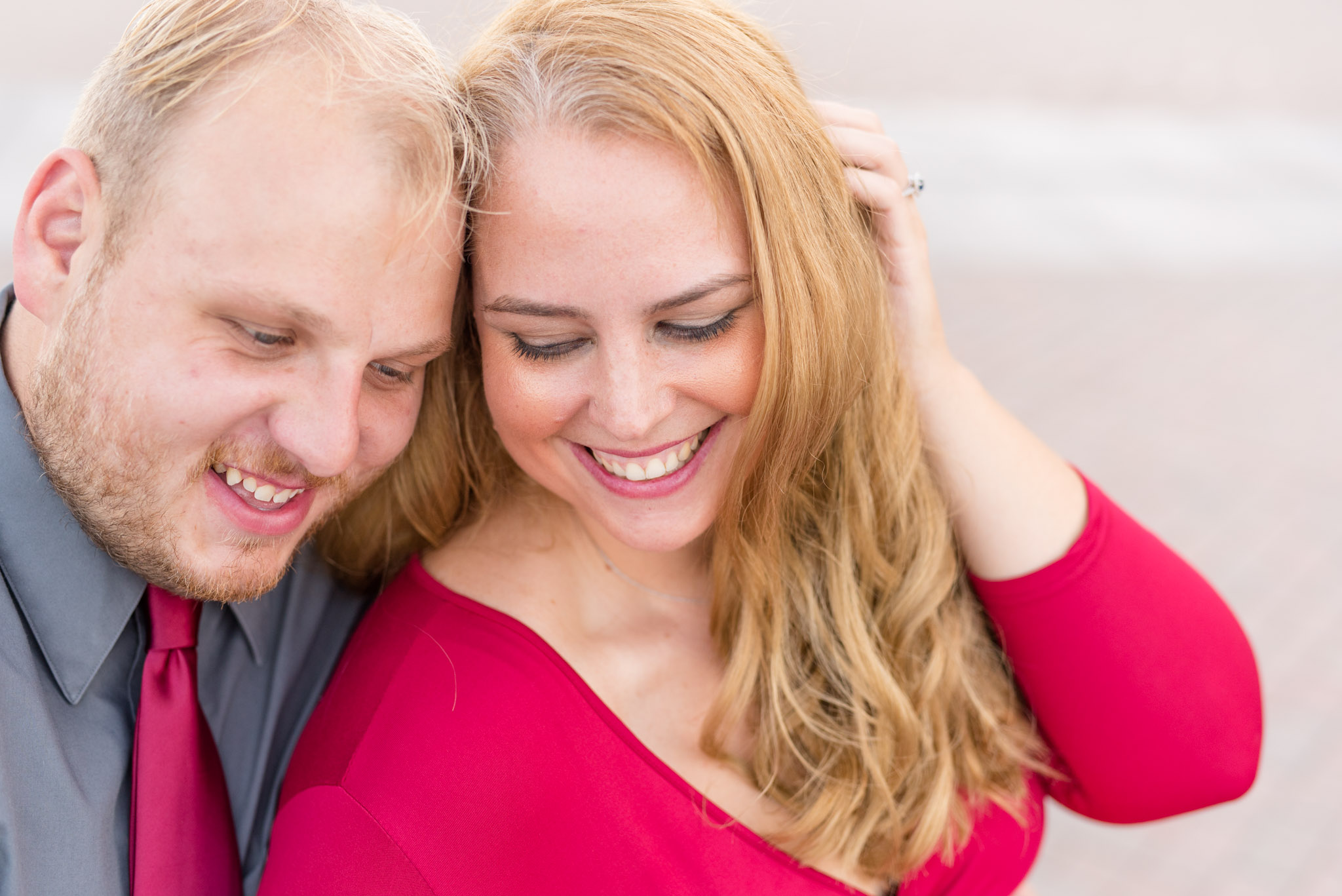 Engaged Couple laughing together while sitting