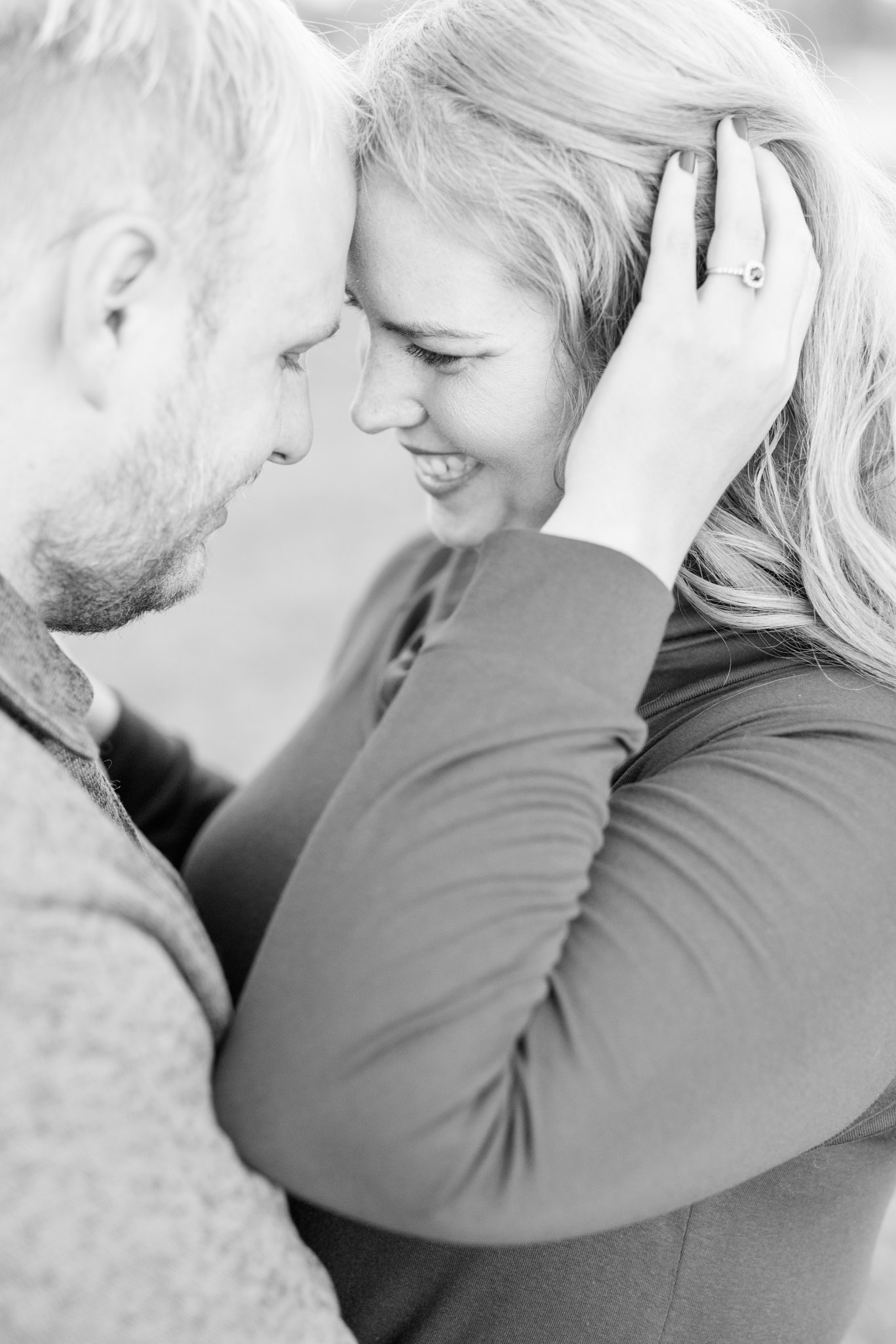 Engaged man and woman touch foreheads and smile.