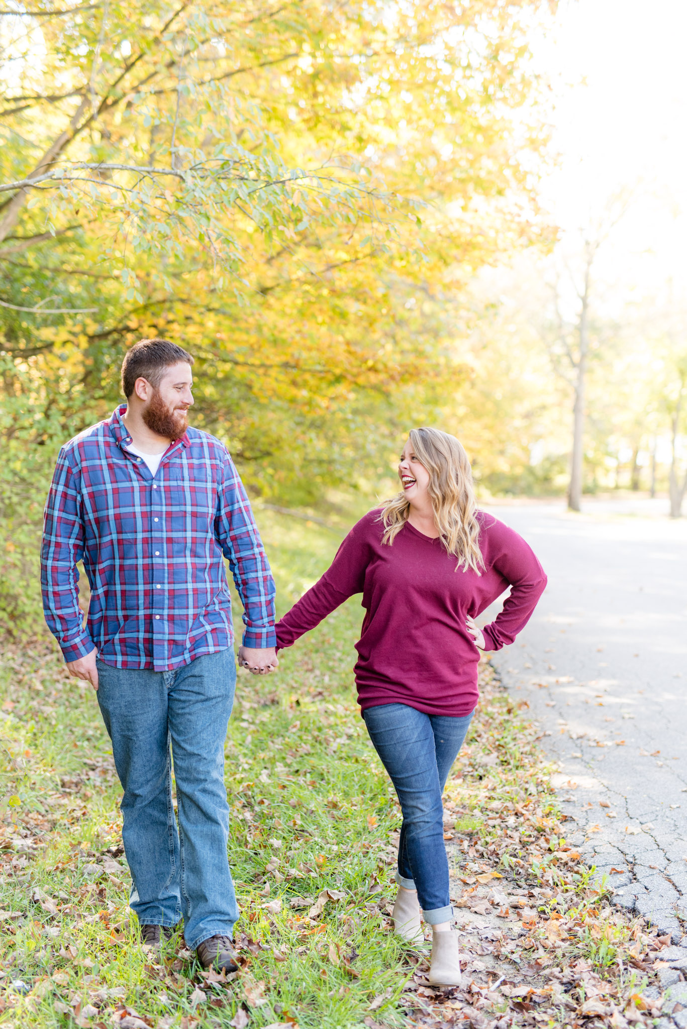 Couple laughs while walking during fall.