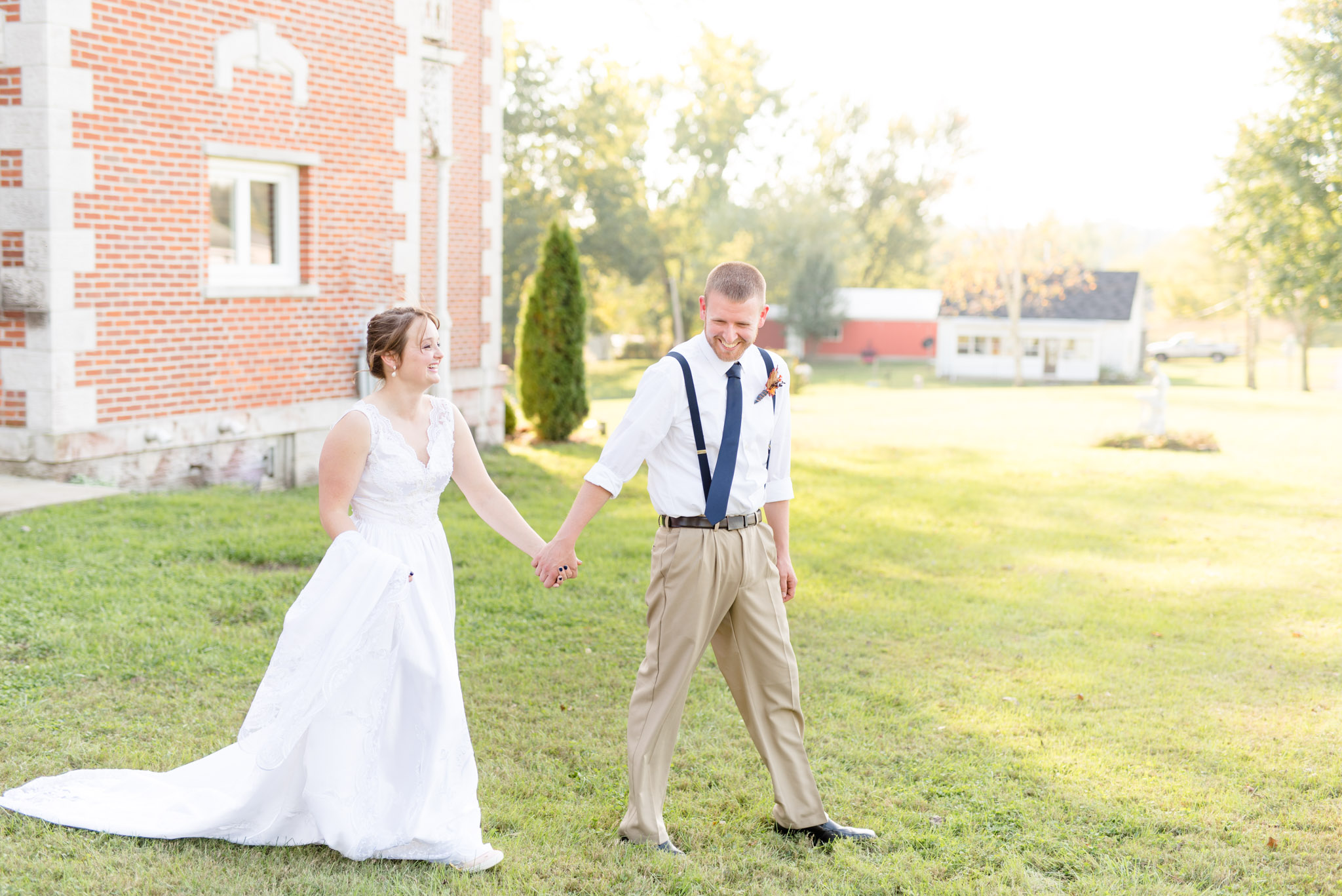 Bride and Groom walk on lawn at wedding.