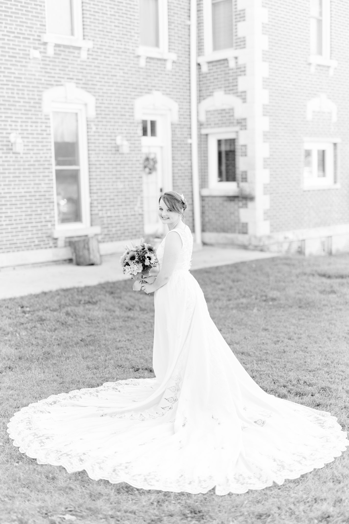 Bride shows off her long train on her mother's gown.