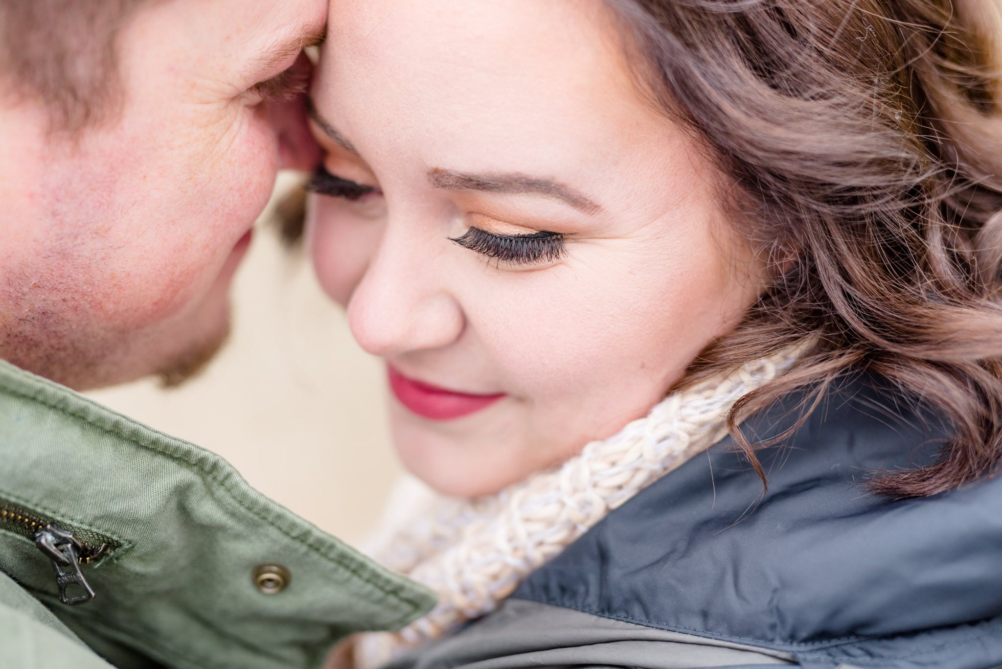 Closeup of engaged bride's makeup while hugging fiance.
