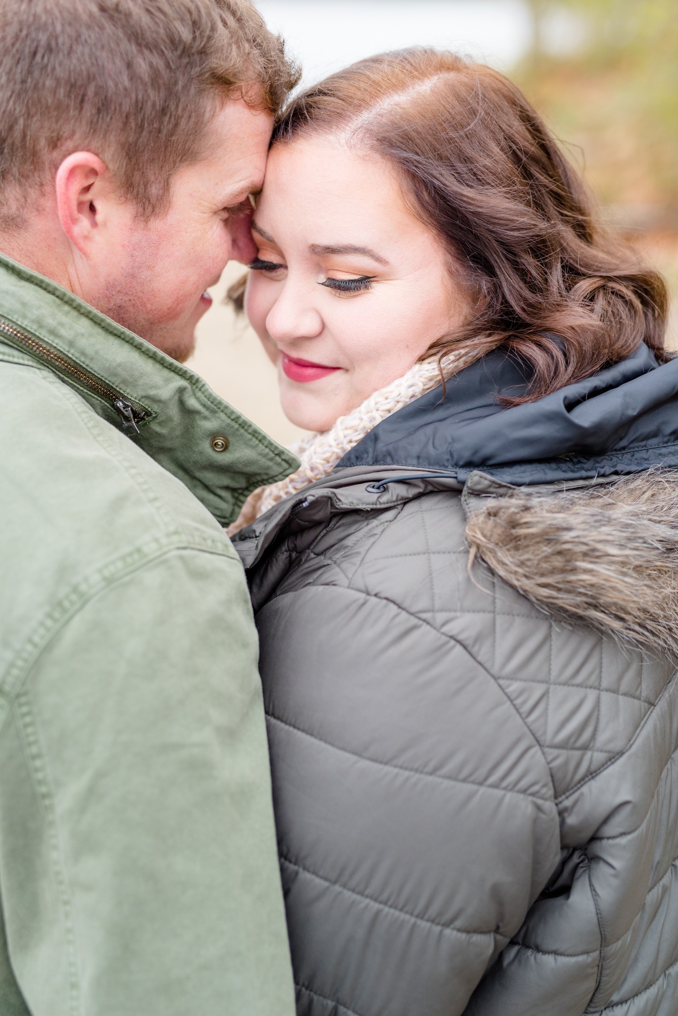 Bride and her fiance snuggle during engagement session.