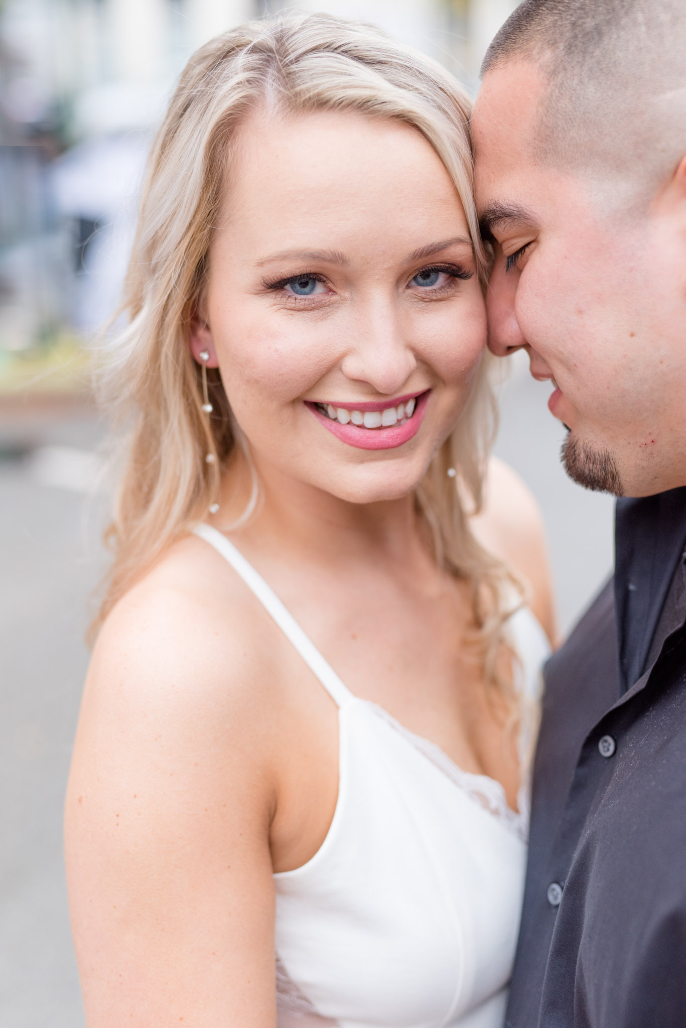 Bride smiles at camera during engagement pictures.
