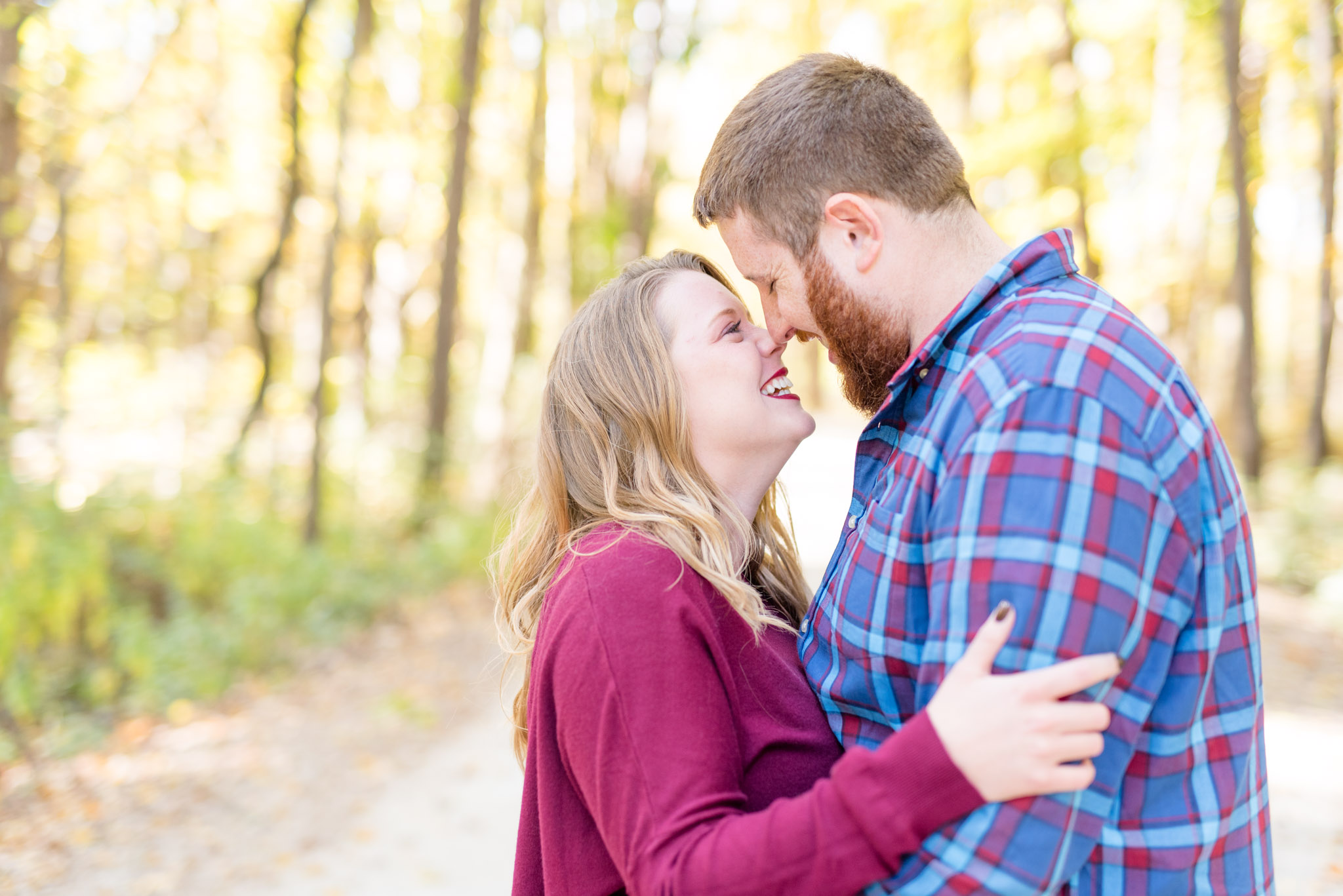 Couple laughs during fall engagement session.