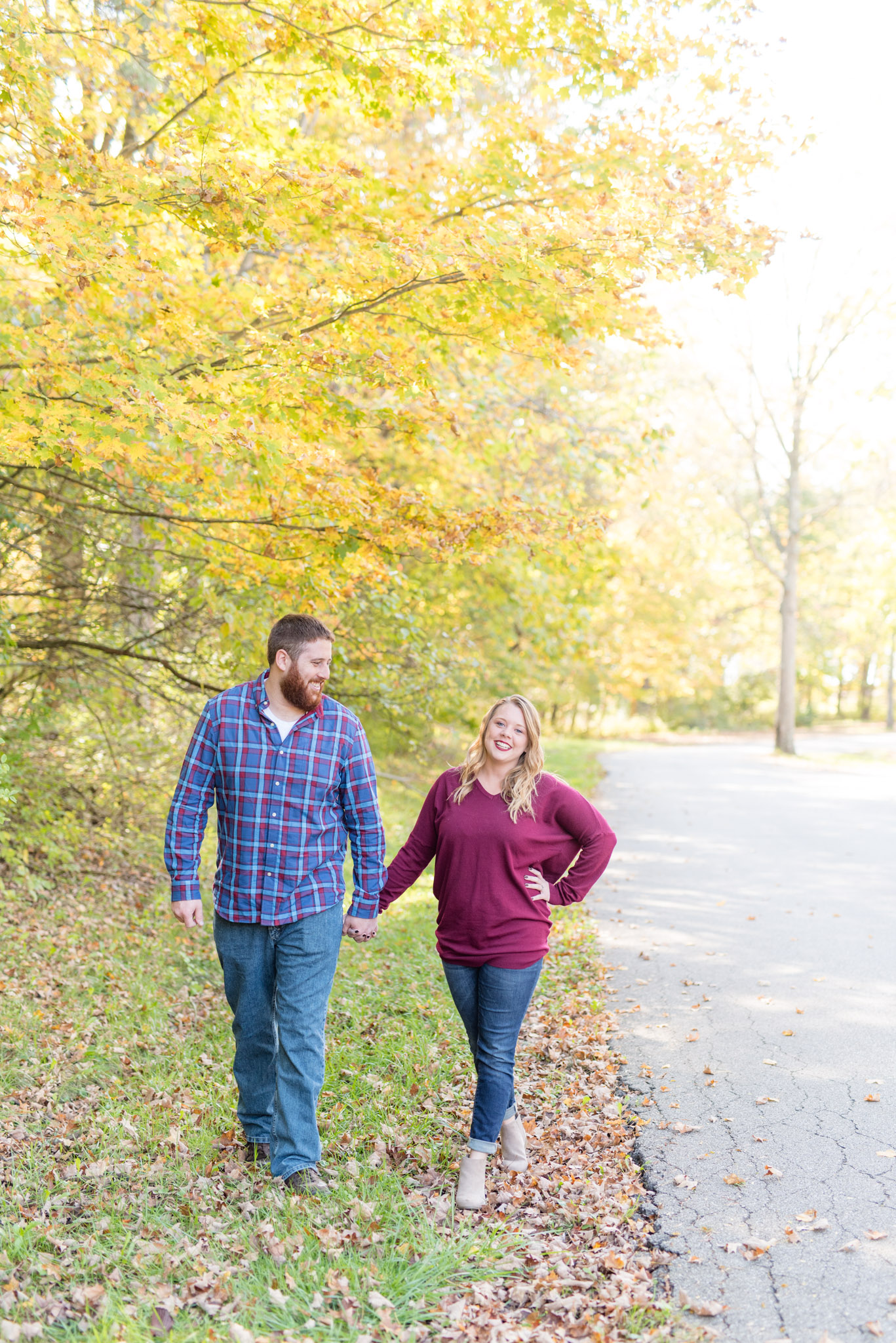 Couple walks on forest path during fall.
