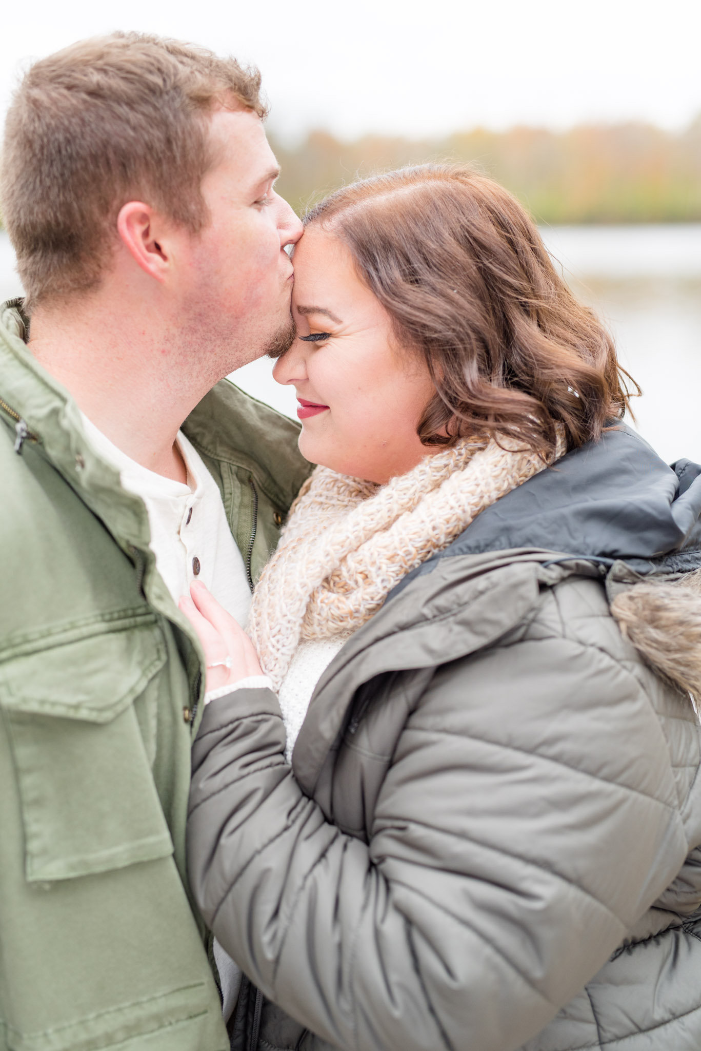 Groom kisses fiancee on forehead.