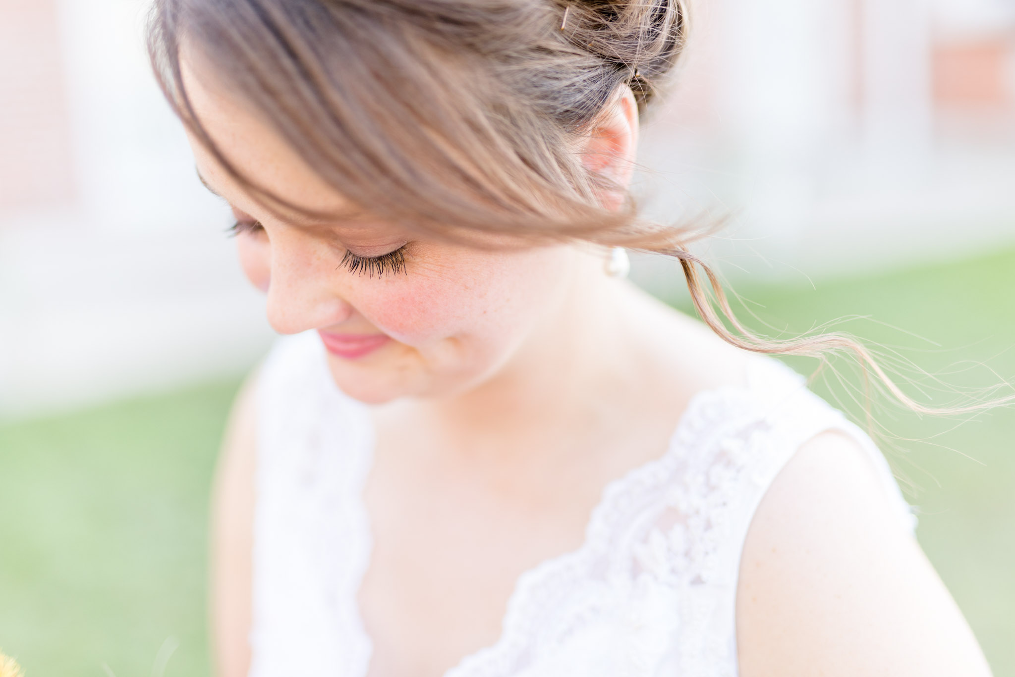 Bride looks down and smiles.