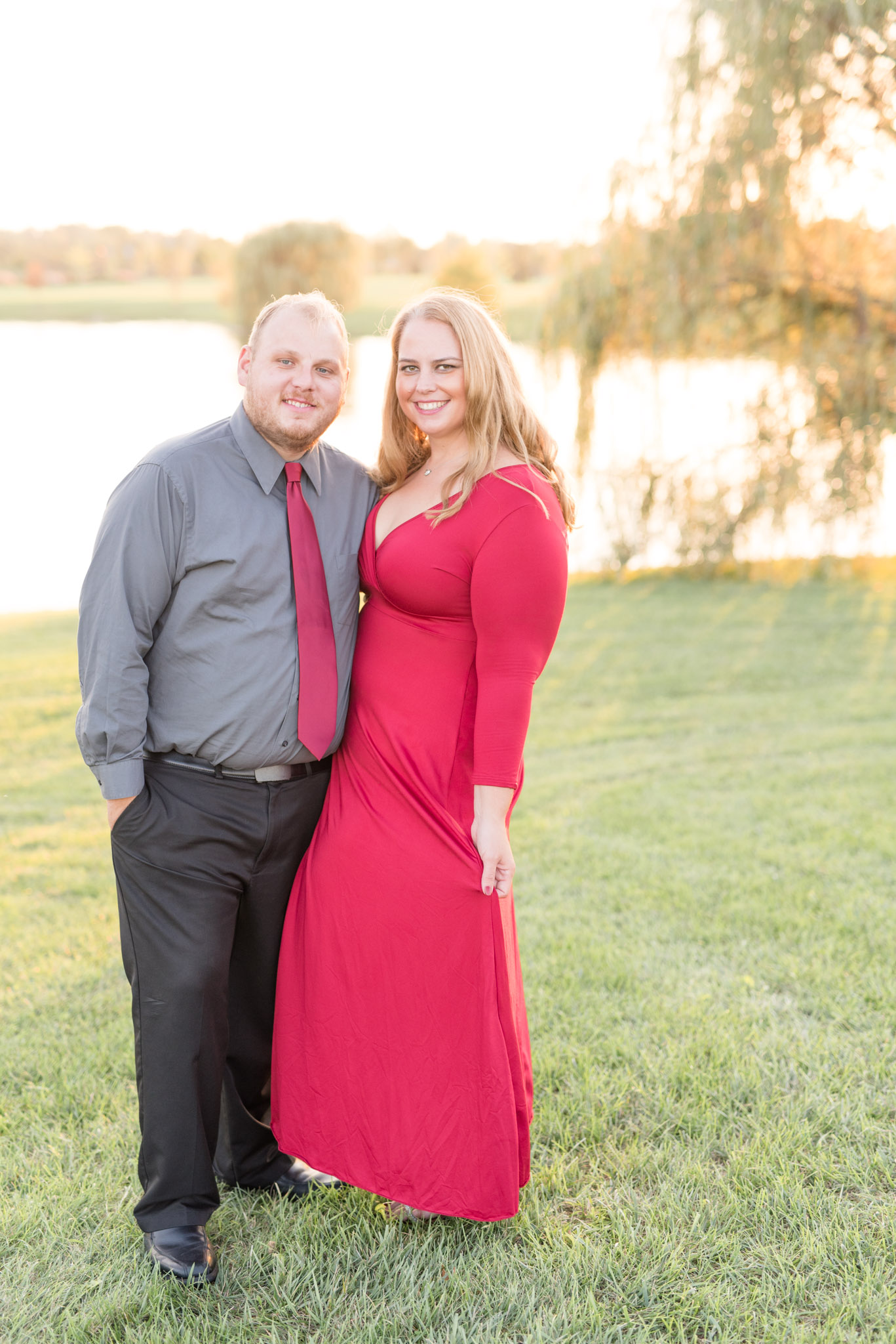 Engaged Couple smiles at camera during sunset.